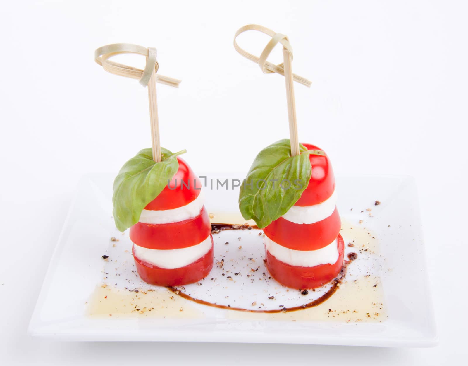 tasty tomatoe mozarella salad with basil isolated on white background