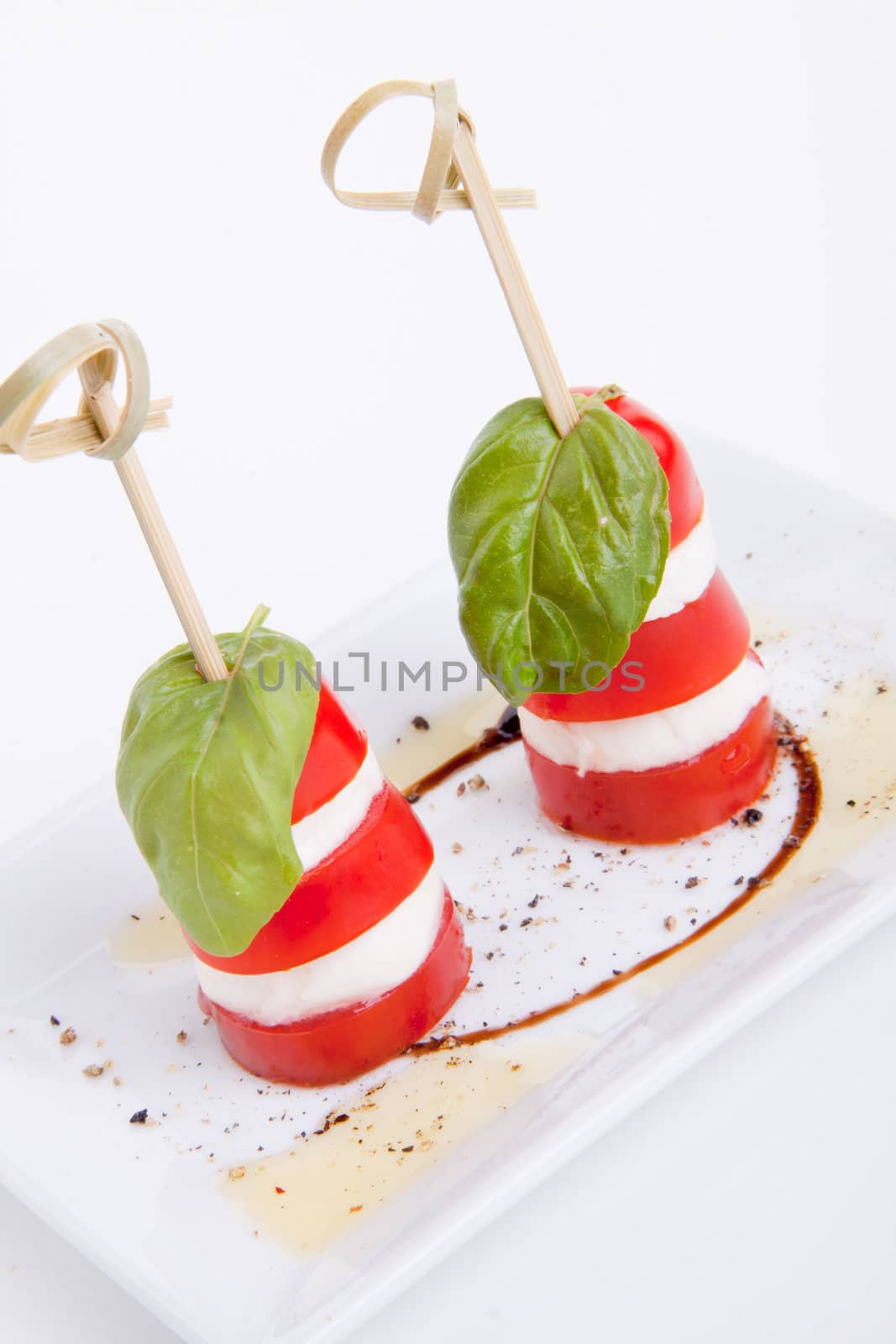 tasty tomatoe mozarella salad with basil isolated on white background
