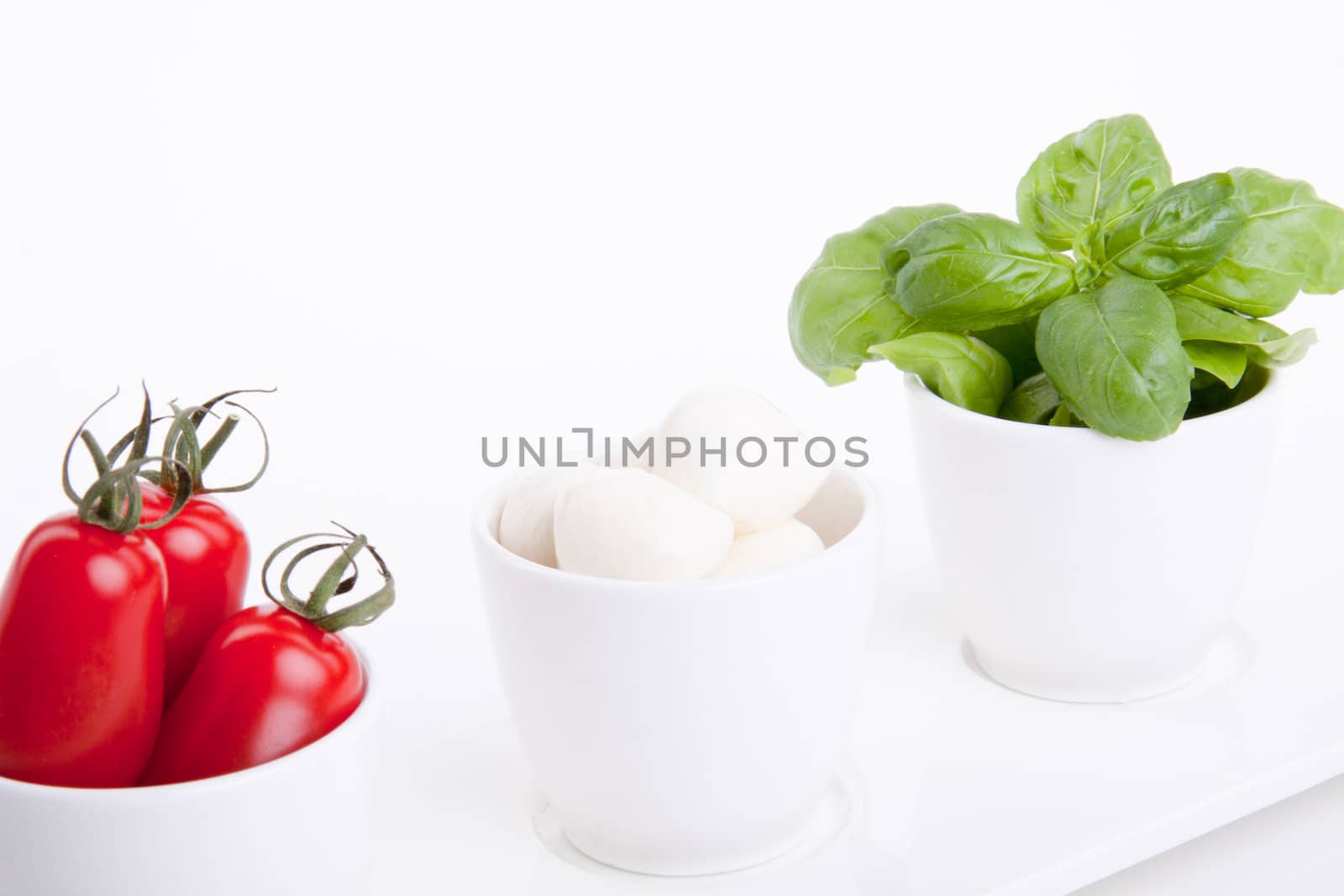 tasty tomatoe mozarella salad with basil isolated on white background