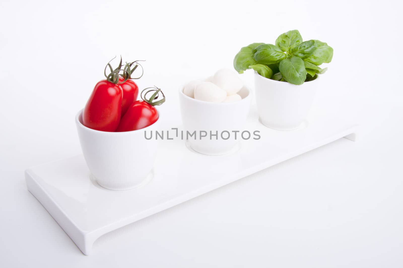 tasty tomatoe mozarella salad with basil isolated on white background