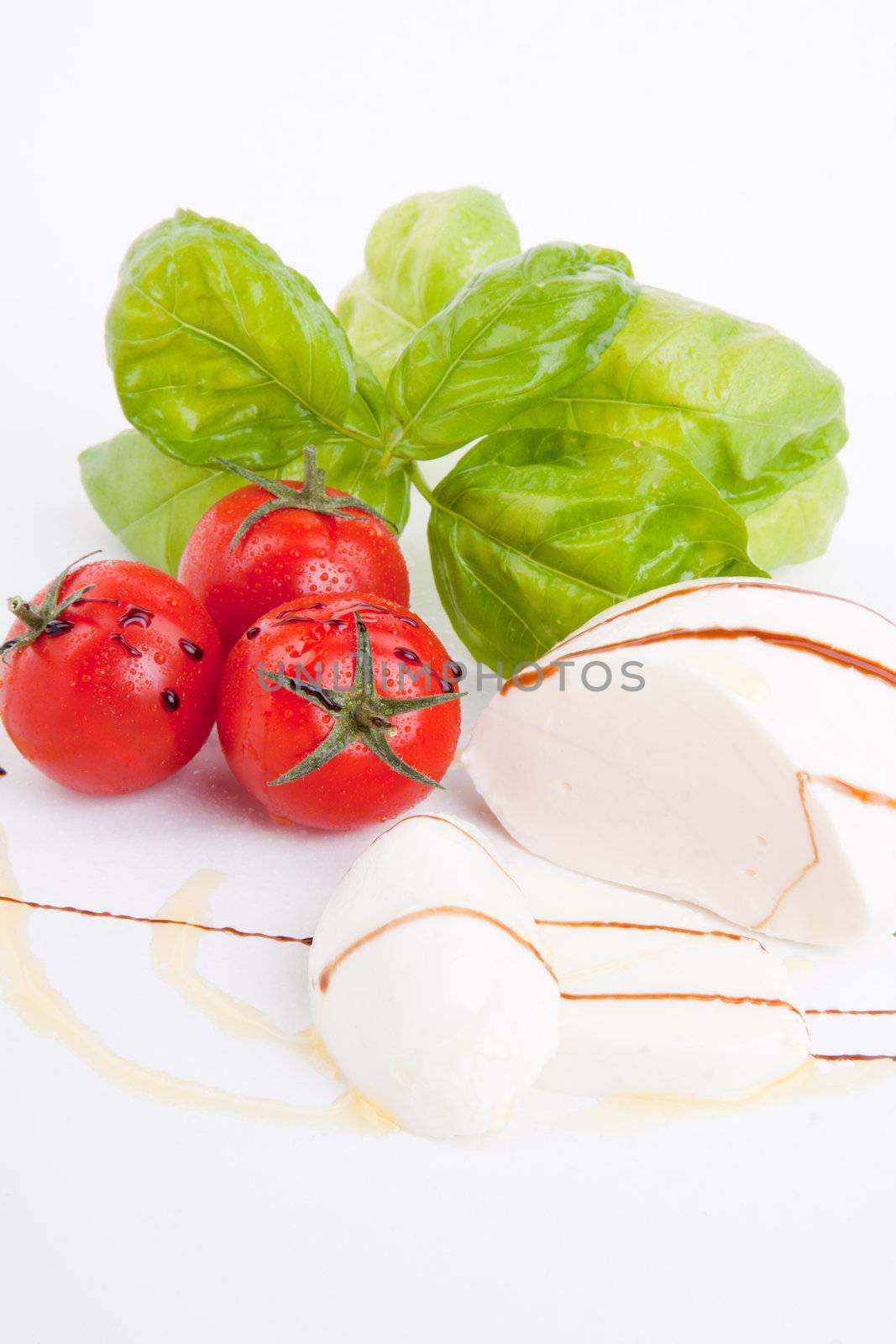 tasty tomatoe mozarella salad with basil isolated on white background