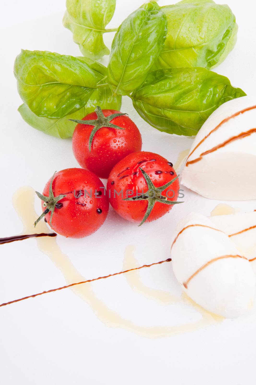 tasty tomatoe mozarella salad with basil isolated on white background