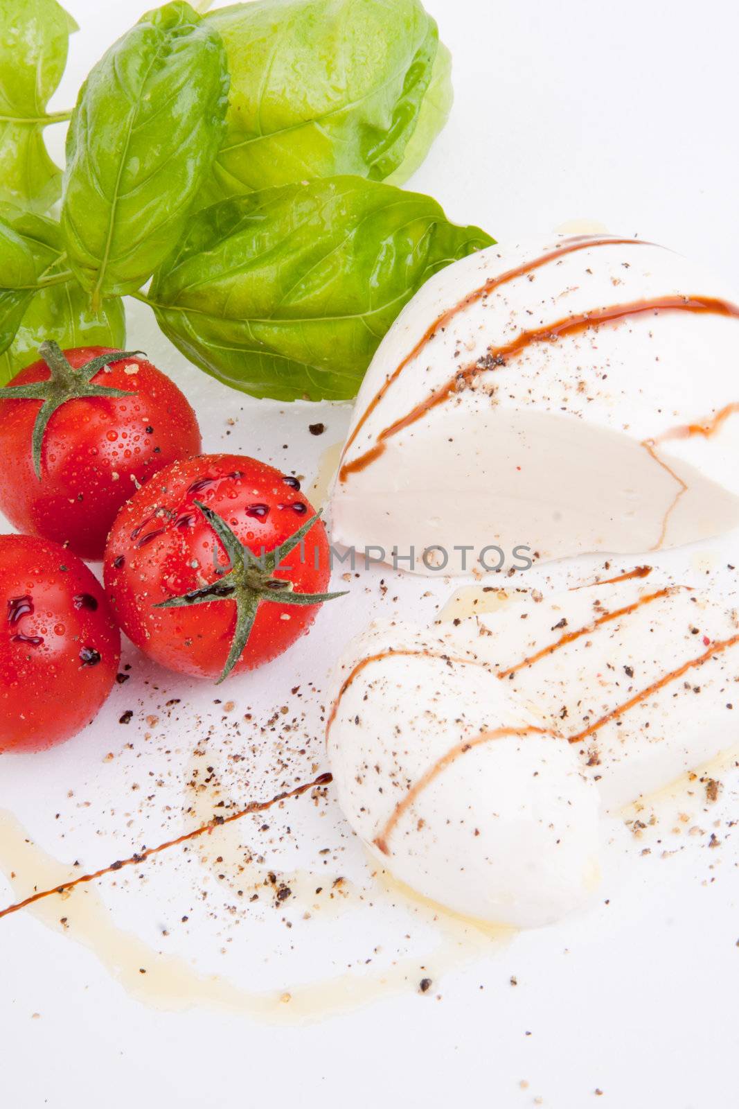 tasty tomatoe mozarella salad with basil isolated on white background