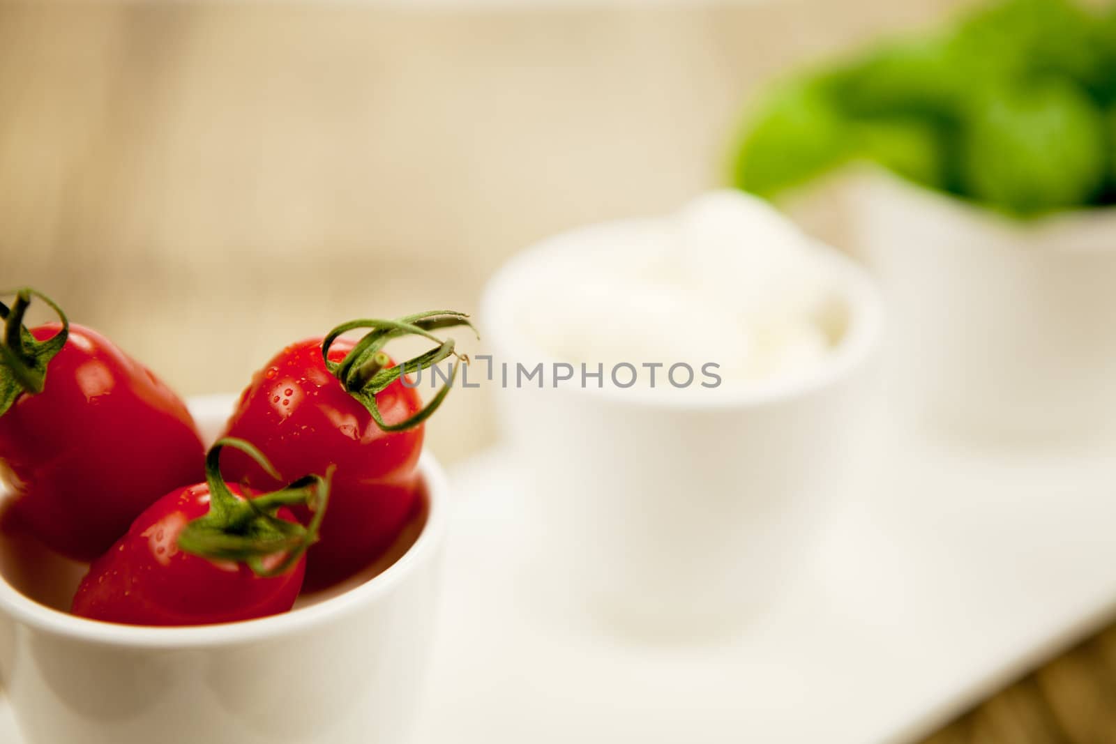 tasty tomatoes mazarella and basil on plate on wooden background