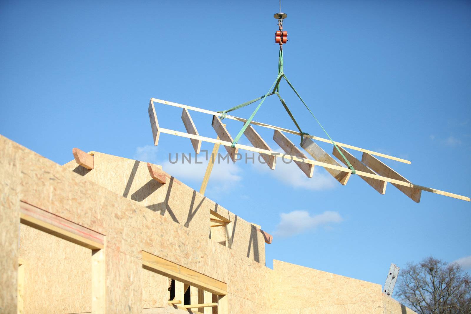 A crane lifting a wood structure. by phovoir