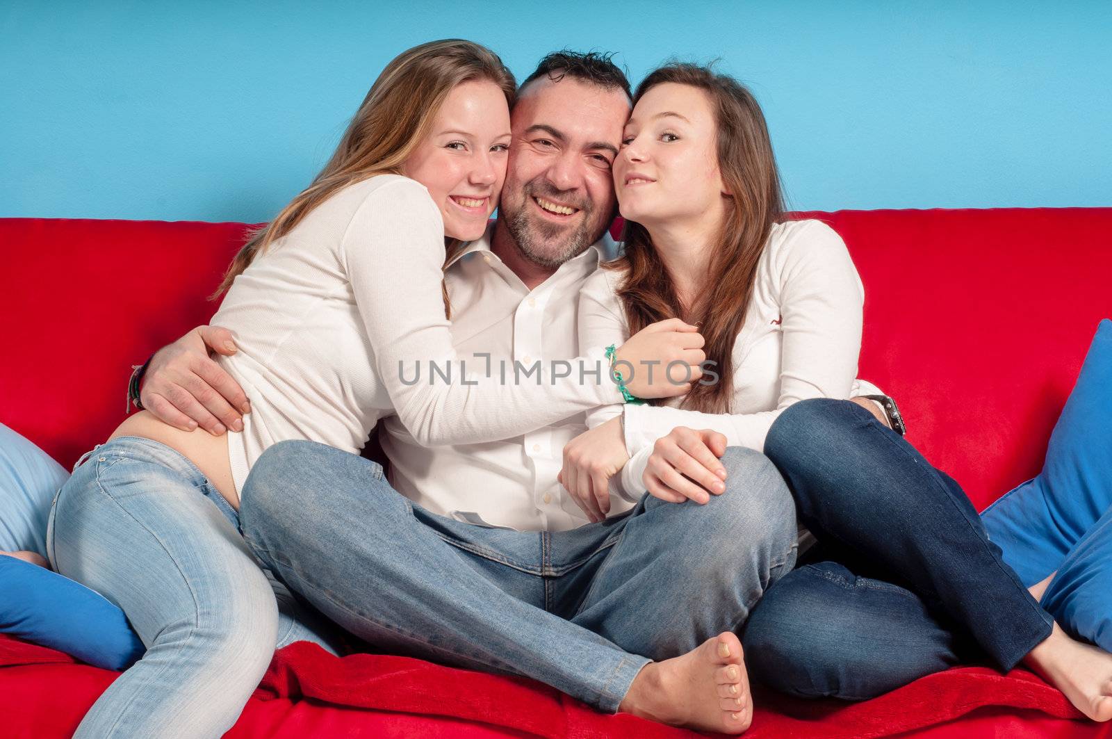 happy father and daughters on the couch by peus