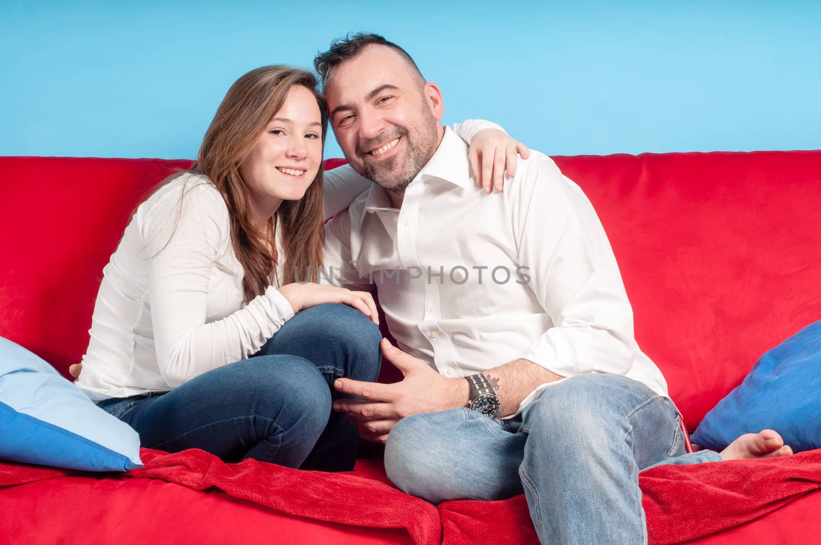 happy father and teenage daughter on the couch in the living room