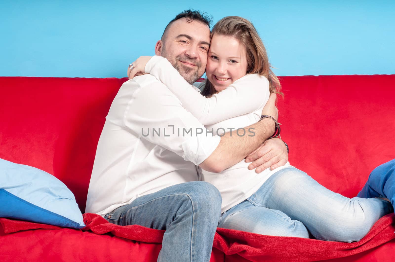 happy father and teenage daughter on the couch in the living room