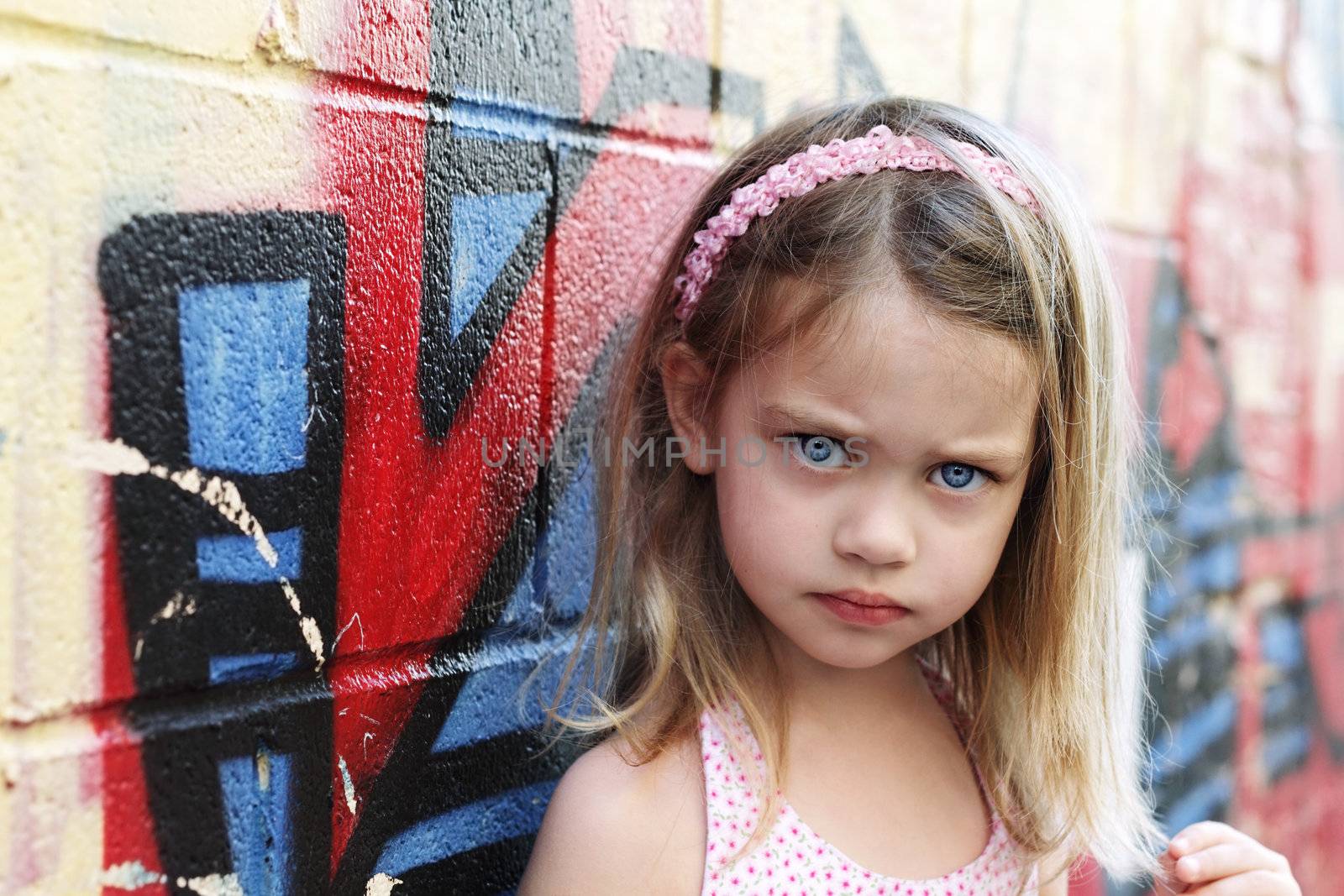 Worried little girl in an urban setting looking into the camera.
