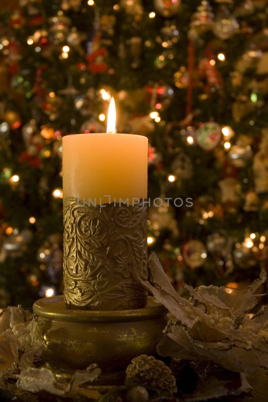 Selective focus on candle with wreath infront of Christmas Tree.