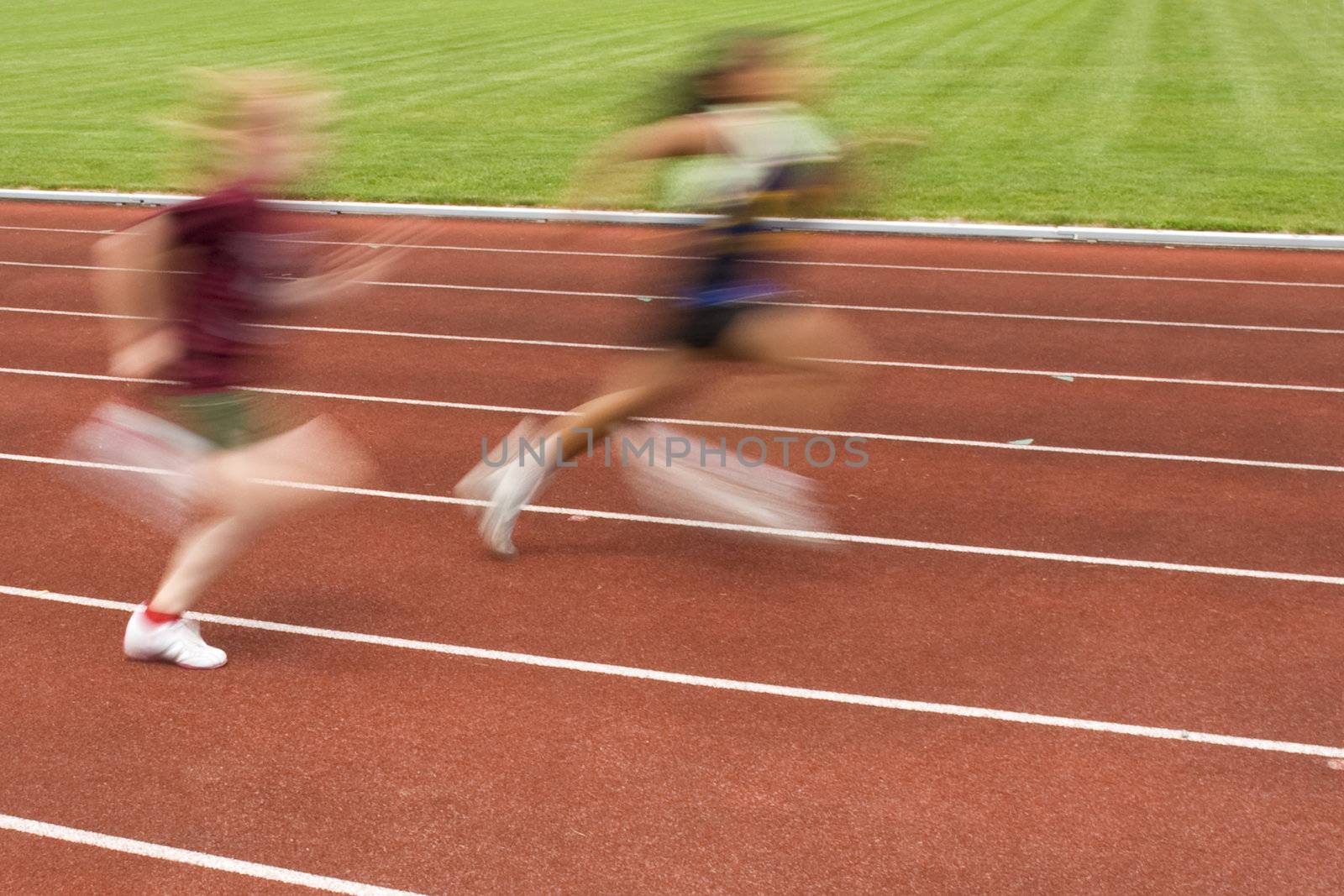 Blurred motion of two females racing on the track