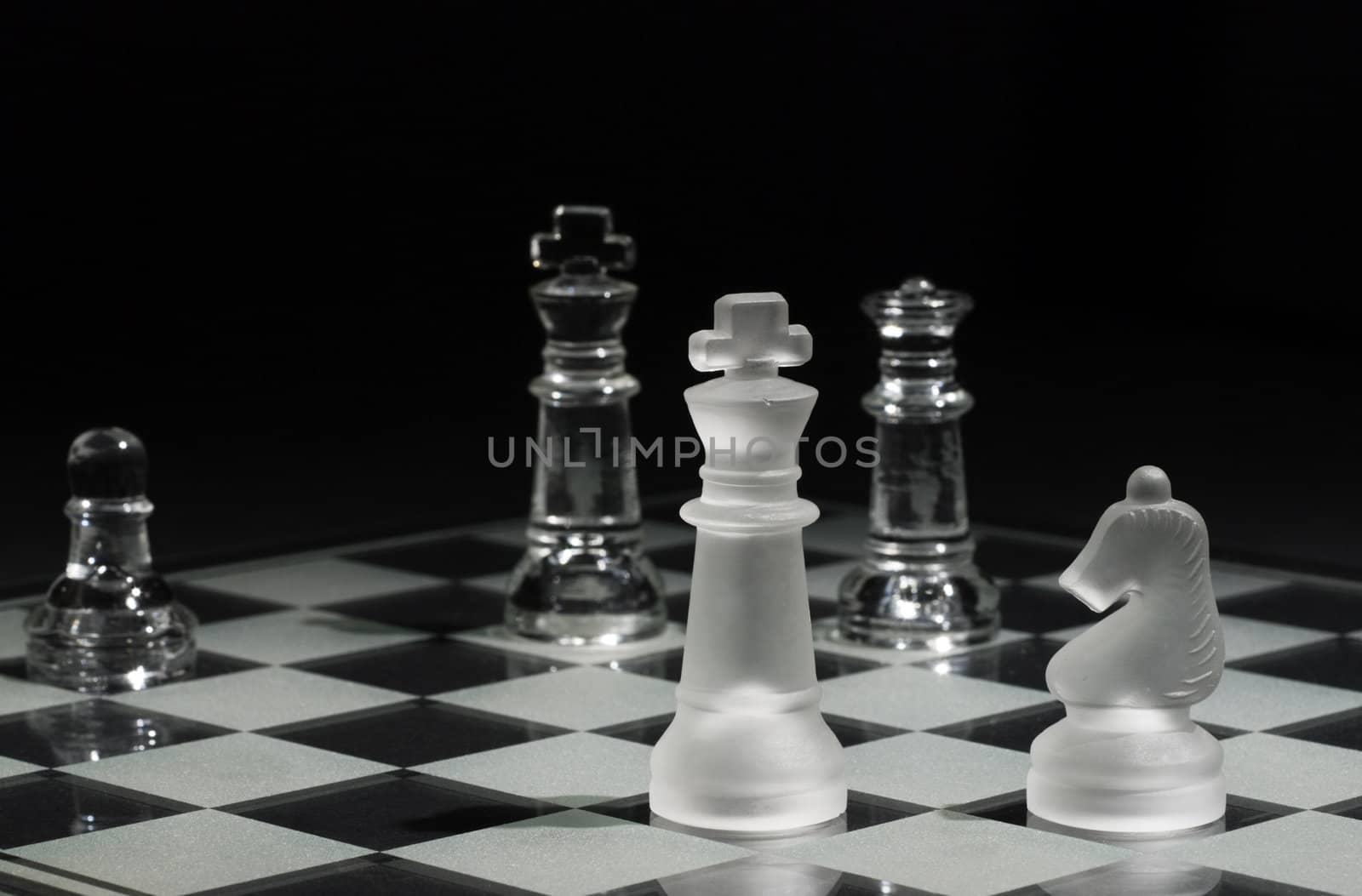 Kings facing each other with one with selective focus and the other in the background, Queen and Knight on the board