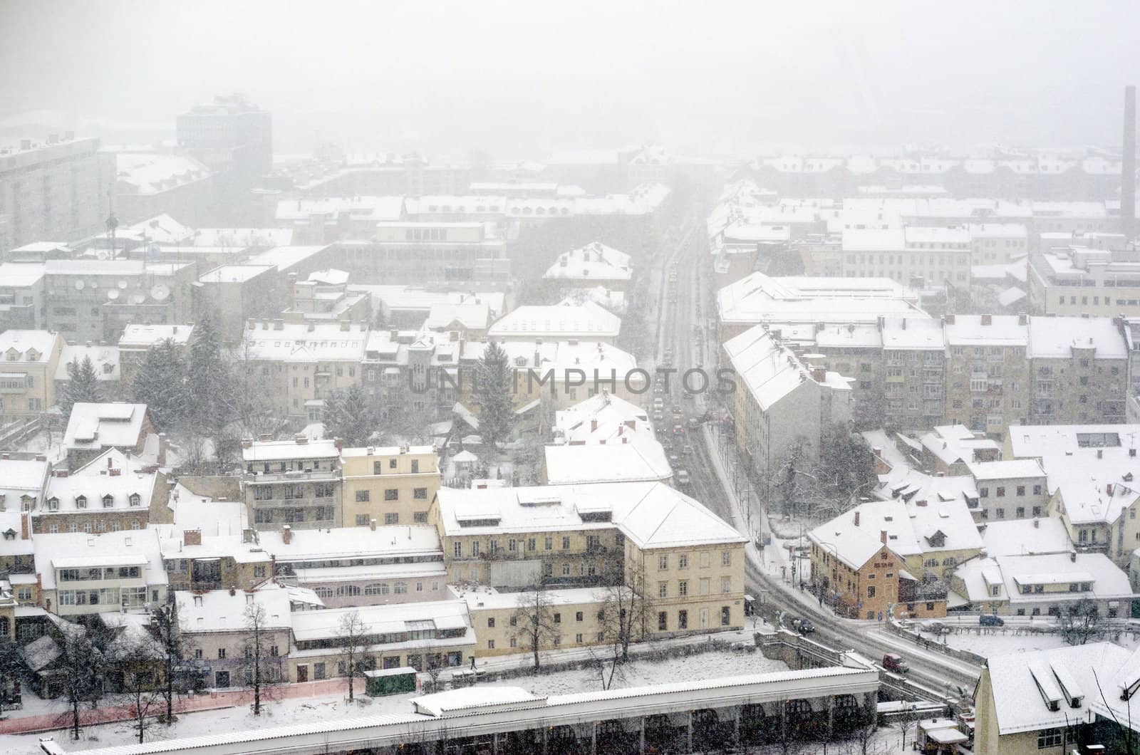 Panoramic view on town with falling snow.