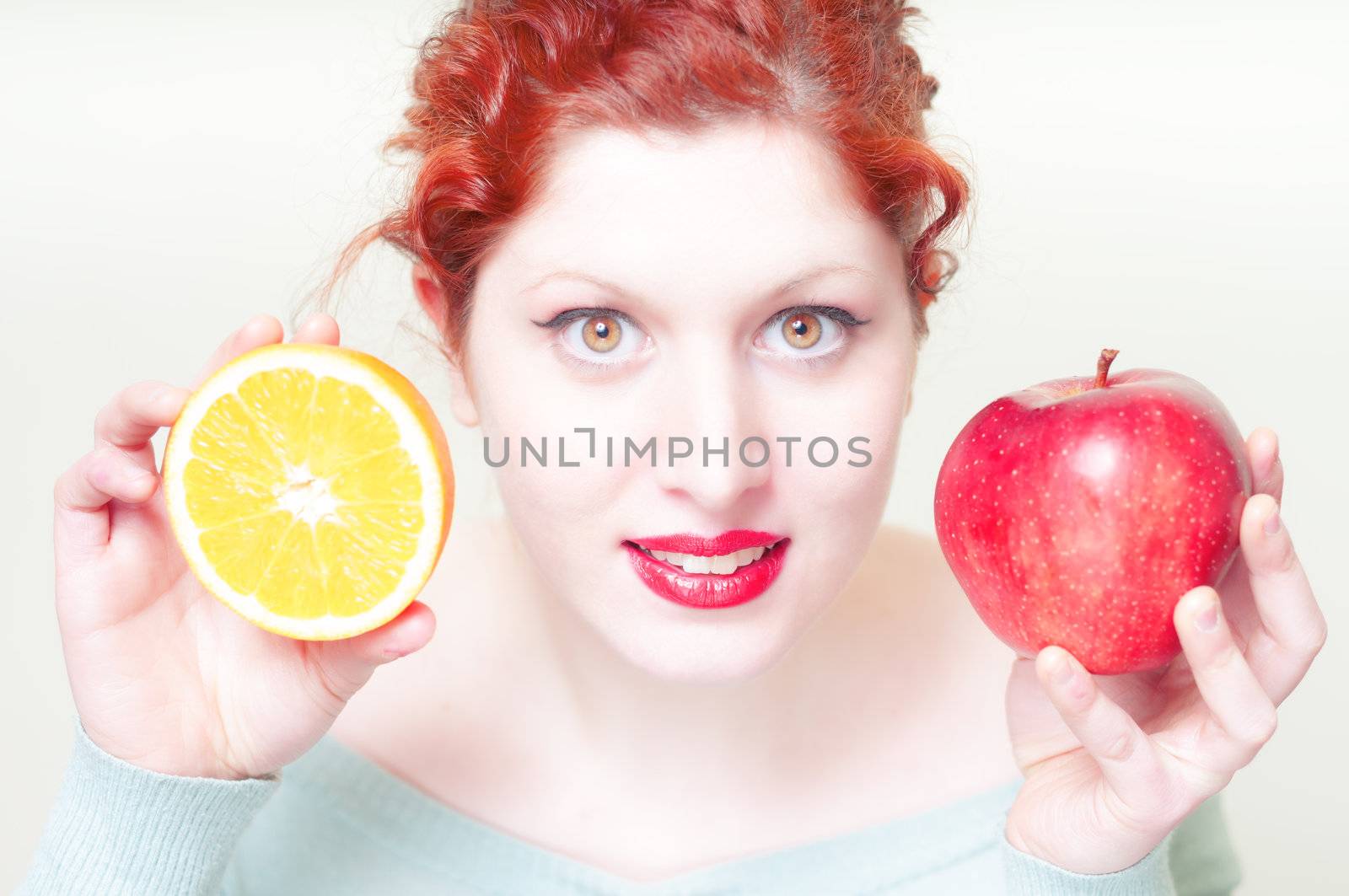 beautiful red hair and lips girl with orange and apple on white background