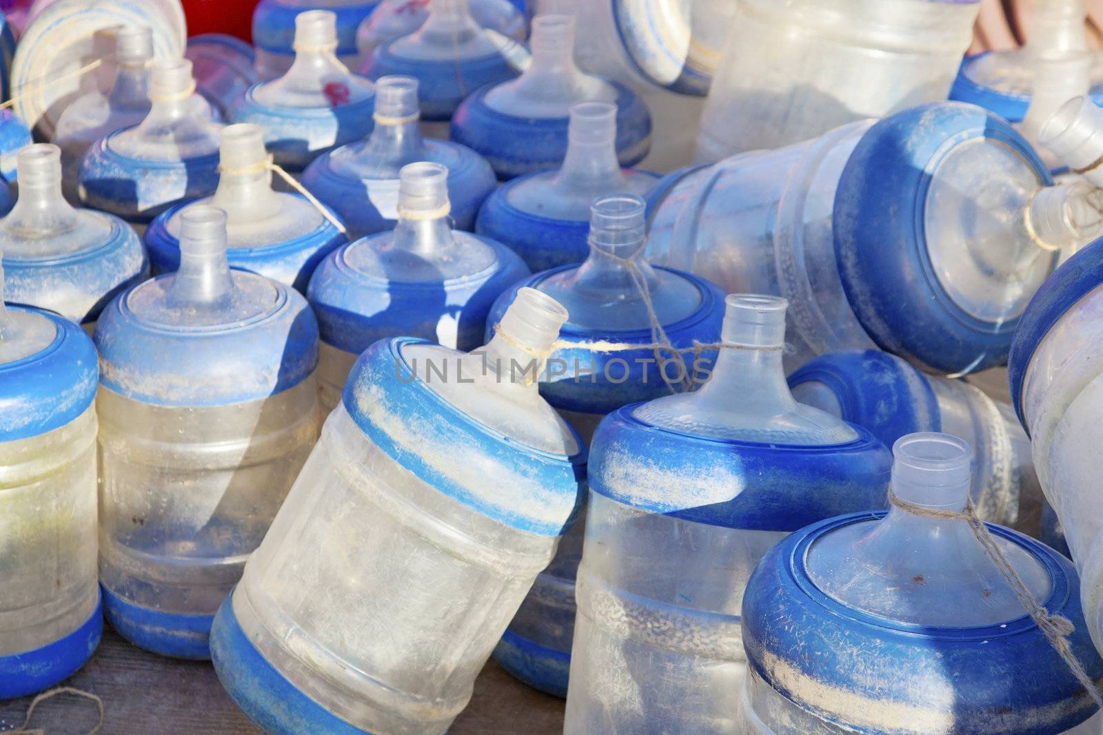 Dwarka Roadtrip. Empty drinking water bottles for dispensers gathering dust on the Quayside. Shot location, Dwarka, Gujarat, India