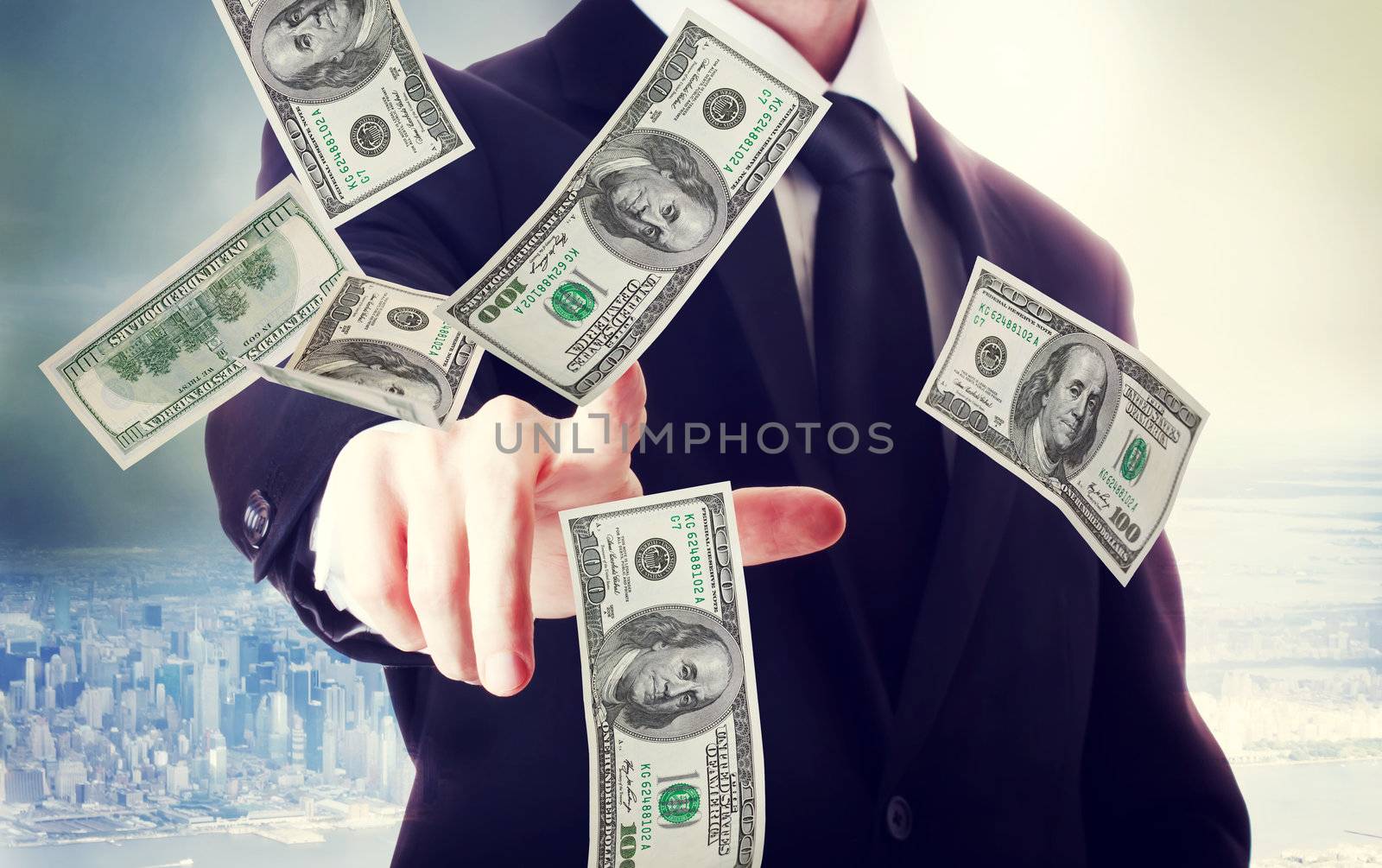 Business man with hundred dollar bills on big city backdrop