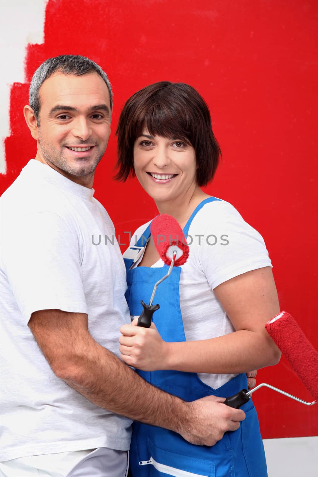 Couple painting a room bright red by phovoir