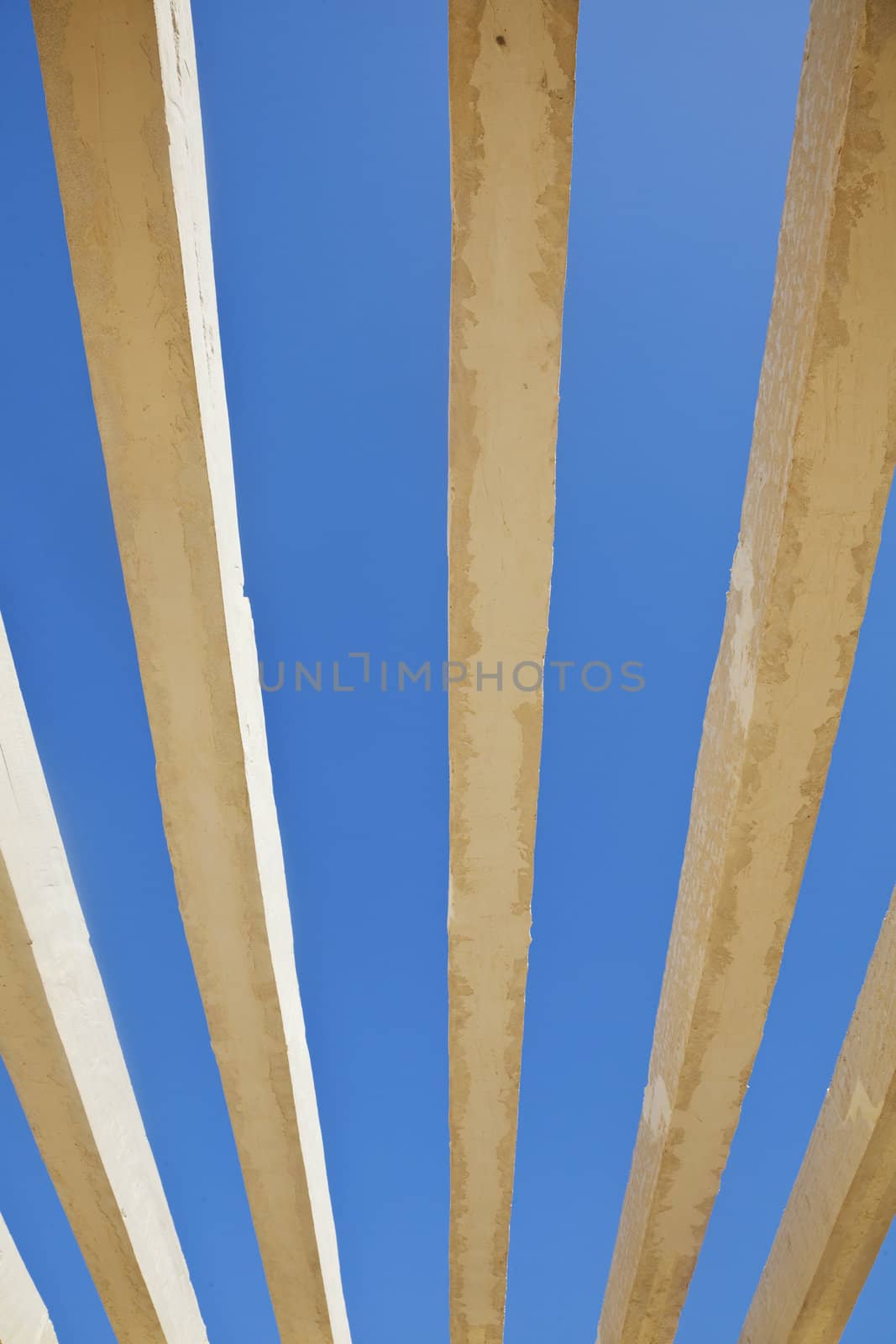 Vertical detail of architecture to the roof of the public acces to Shree Dwarakadheesh Krishna Temple at Dwarka Gujarat India. With no shelter creates an abstract patten of the concrete box work against the rich blue sky withour clouds