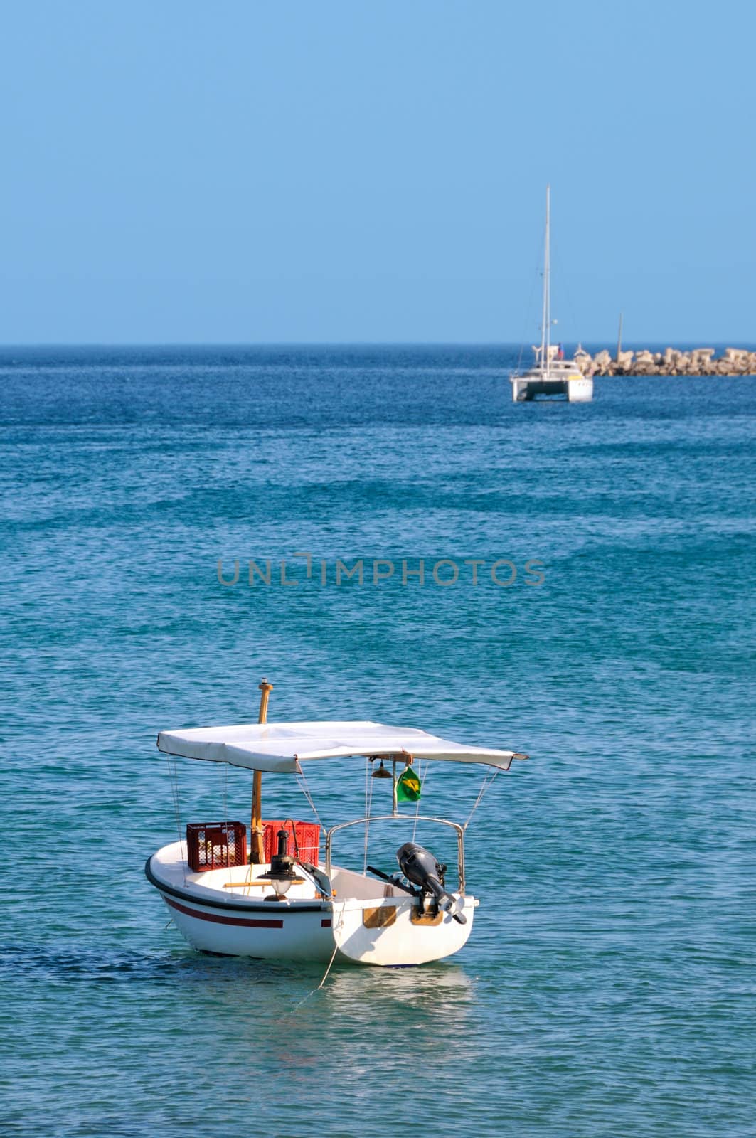 Fishing boat in foreground with catamaran in backgroun