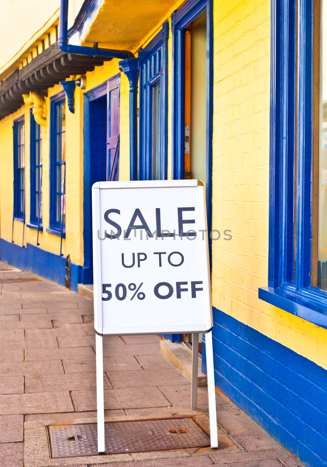 Sale sign outside a vibrant row of shops in England