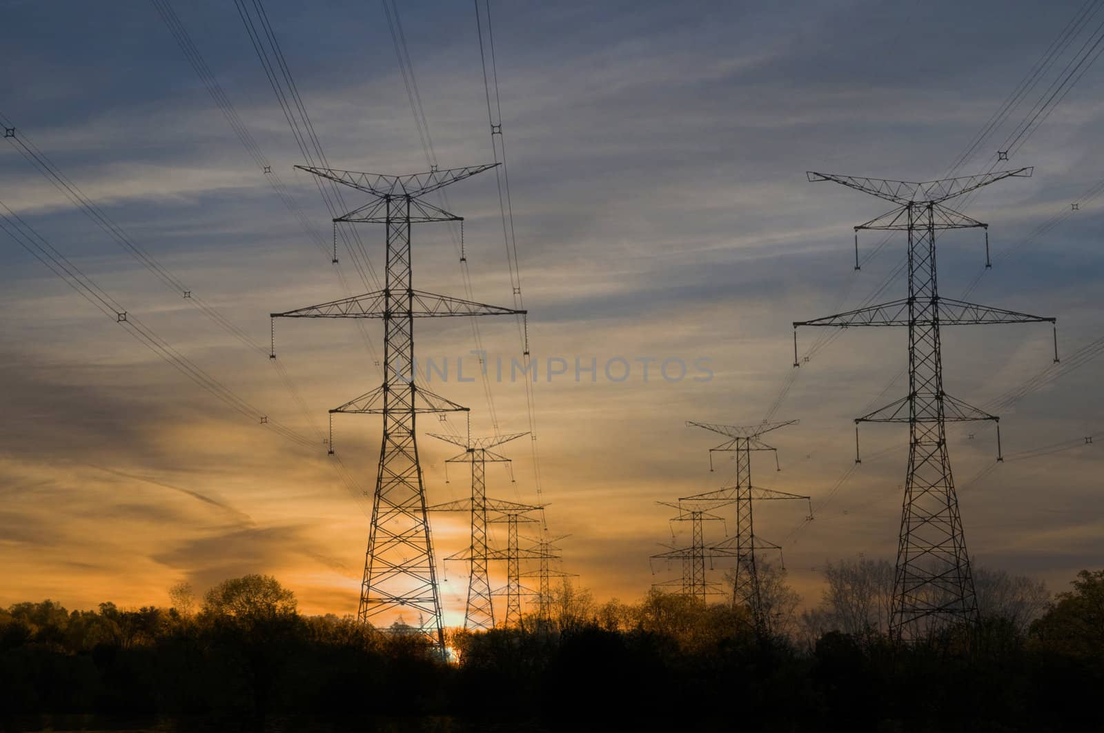 Electric towers through rural area at sunset