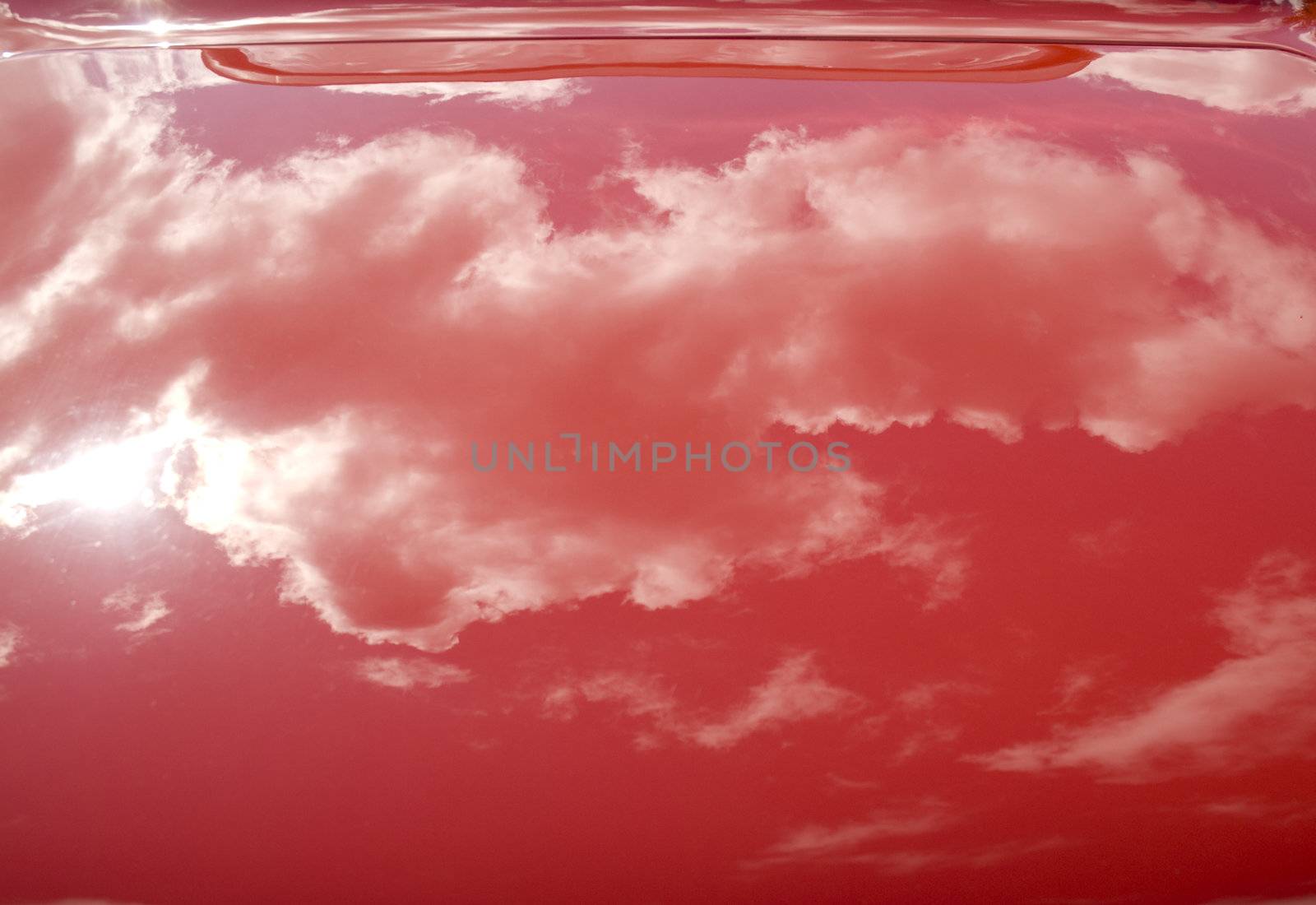 Clouds Reflection on the trunk of a red vintage car