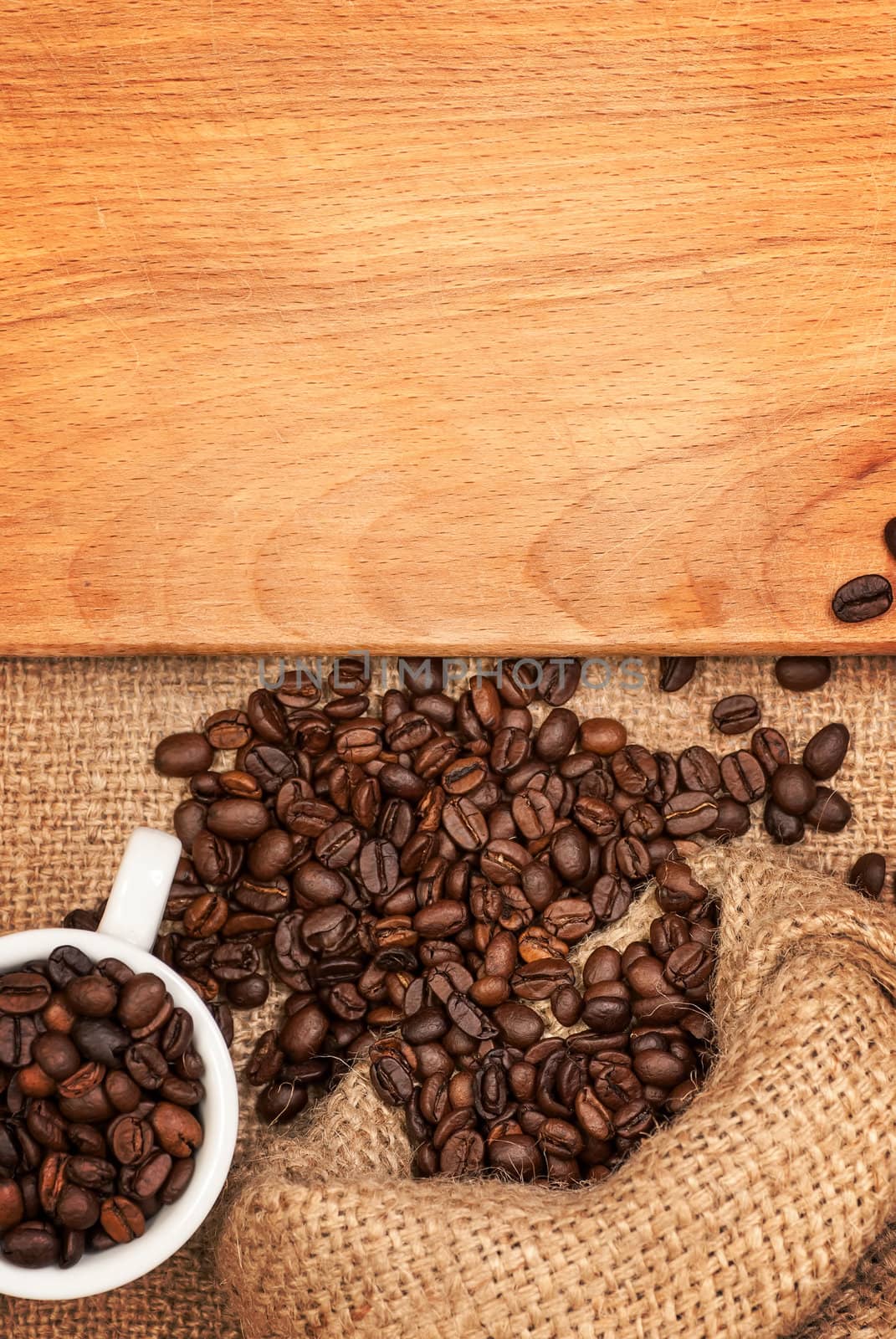 scattered grains of coffee, cup with grains and wooden board