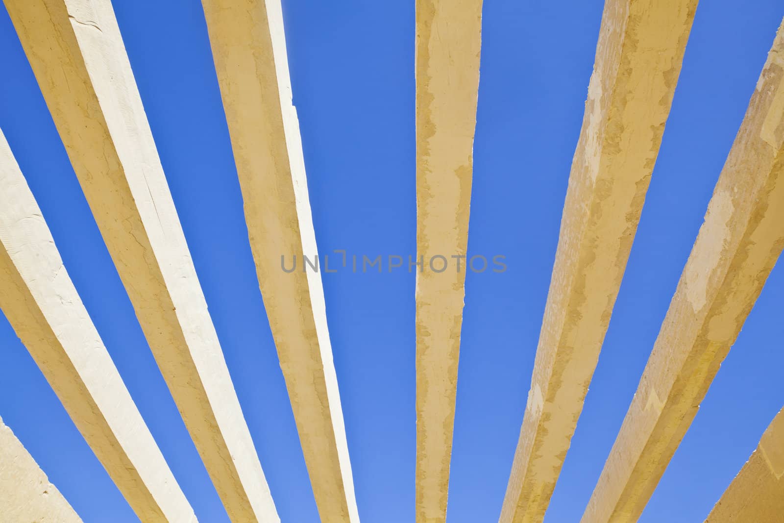 Horizontal detail of architecture to the roof of the public access to Shree Dwarakadheesh Krishna Temple at Dwarka Gujarat India. With no shelter creats an abstract patten of the concrete box work against the rich blue sky withour clouds