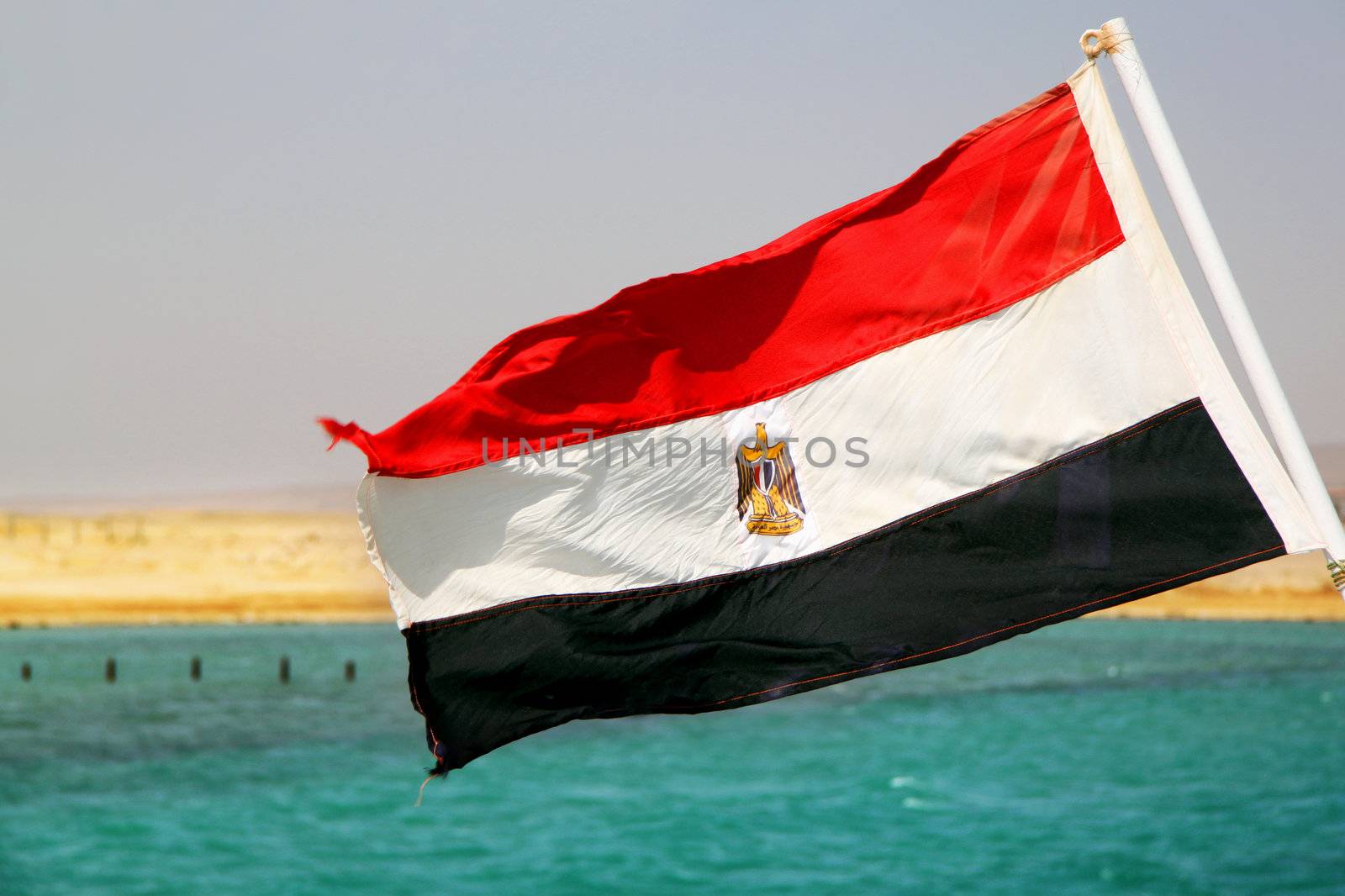 Flag of Egypt on the ship against the sea and sky