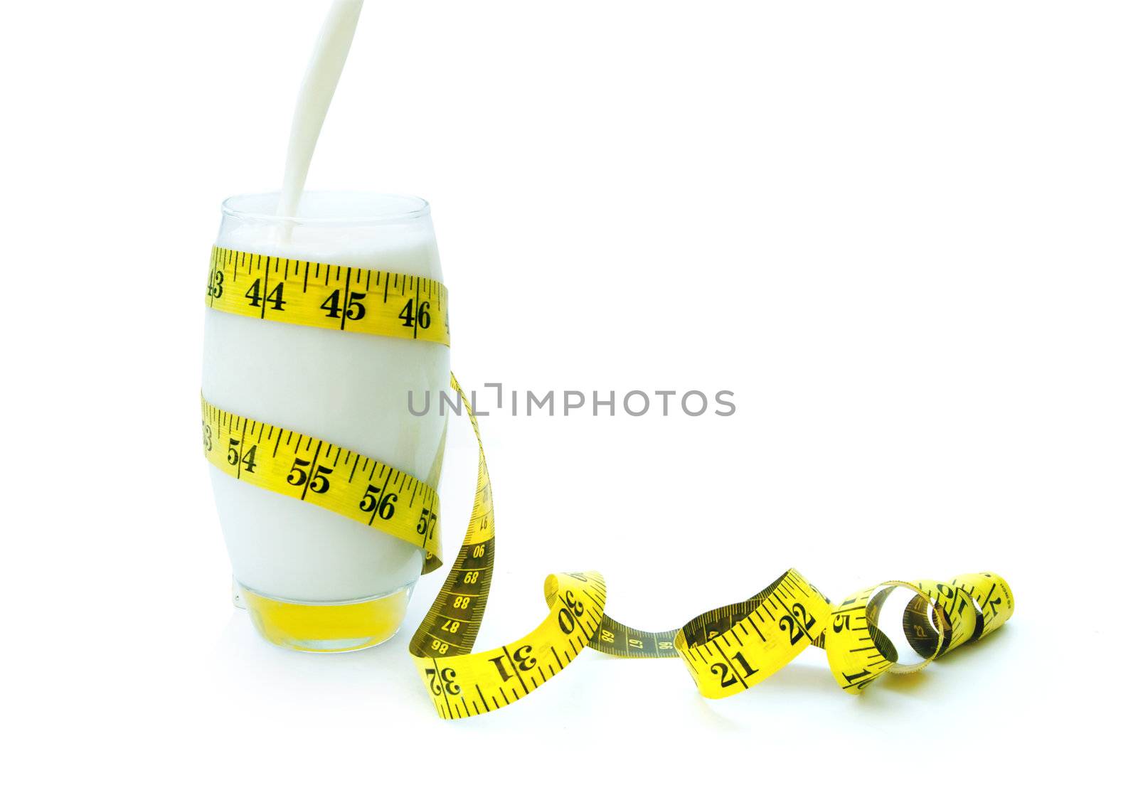 Milk being poured into a galss with a measuring tape