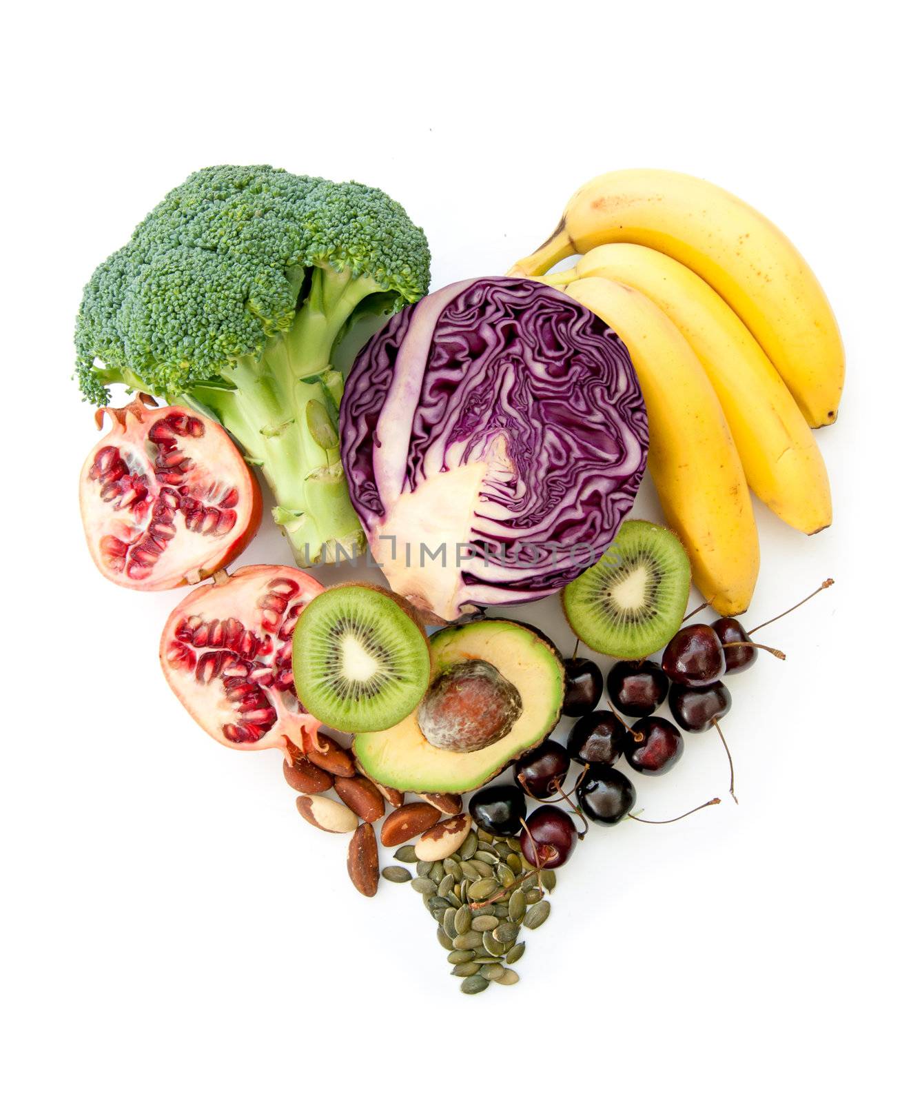 Foods with high nutritional value in a heartshape including red cabbage, avocado and pomegranate