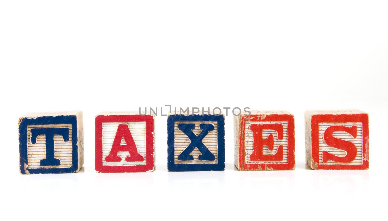 Children blocks spelling "TAXES" on a white background