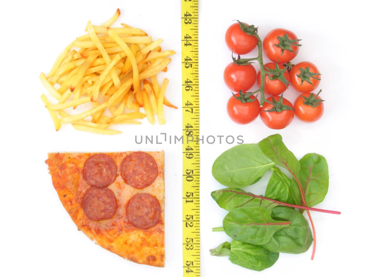 Fast food pizza and french fries on one side of a measuring tape with cherry tomatoes and salad leaves on the other 