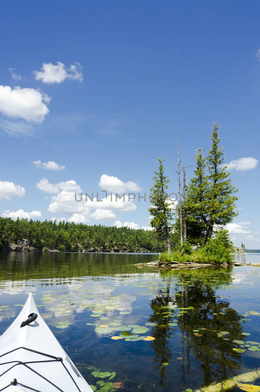 Sunny scenic with kayak in the foreground with small island on a northern lake