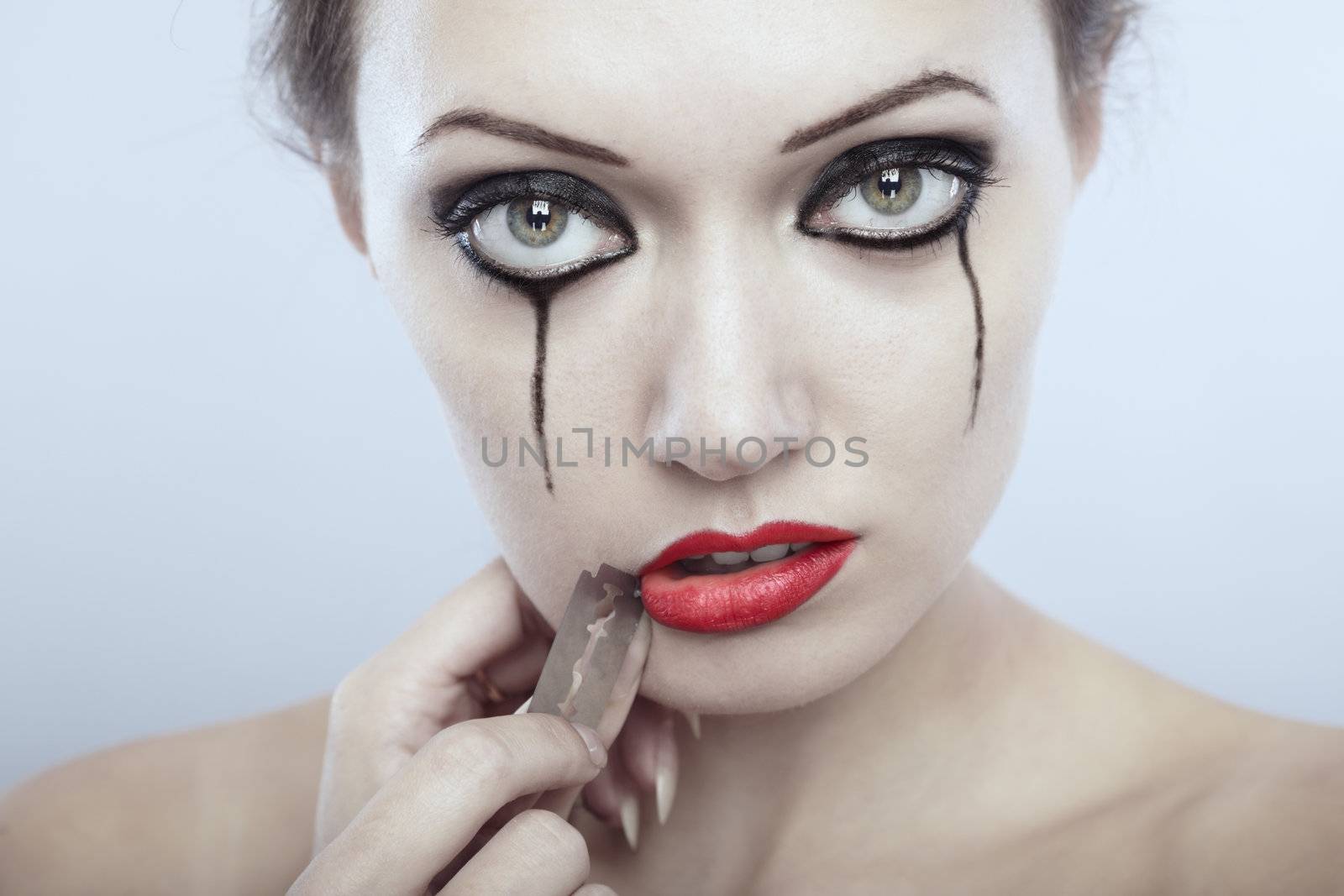 Crying lady cutting her lips by razor