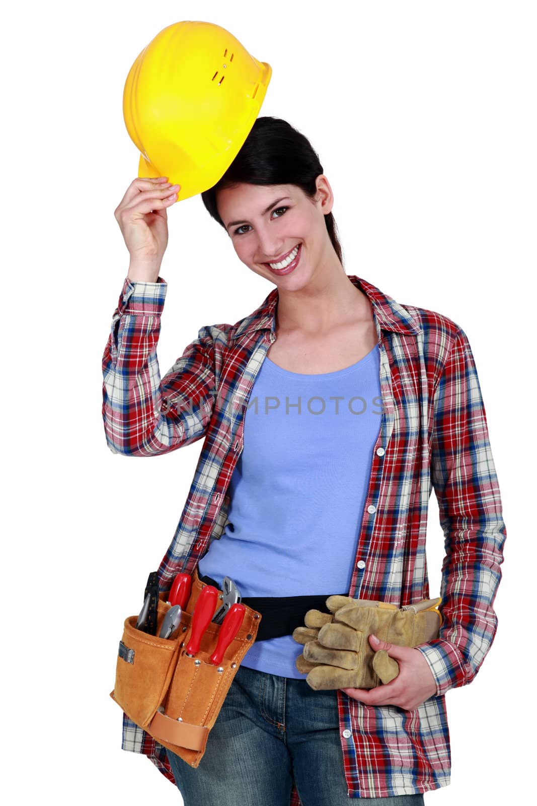 Tradeswoman putting on her hard hat by phovoir