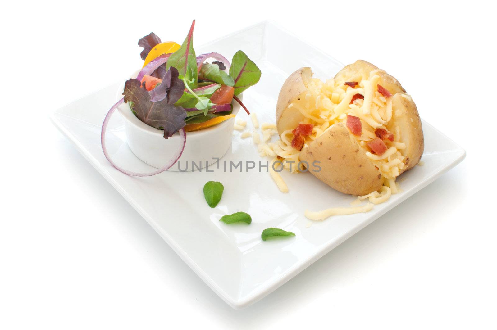 Grated cheese and bacon pieces with baked potato over a white background