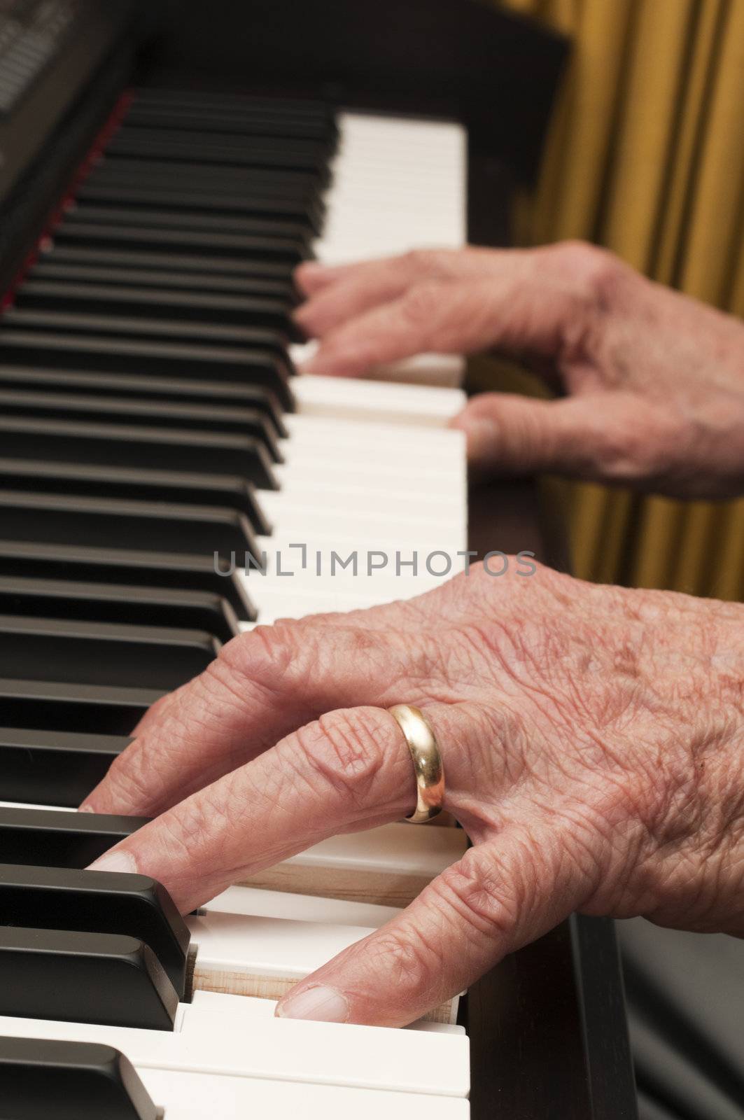 Selective focus on old hands playing the piano 