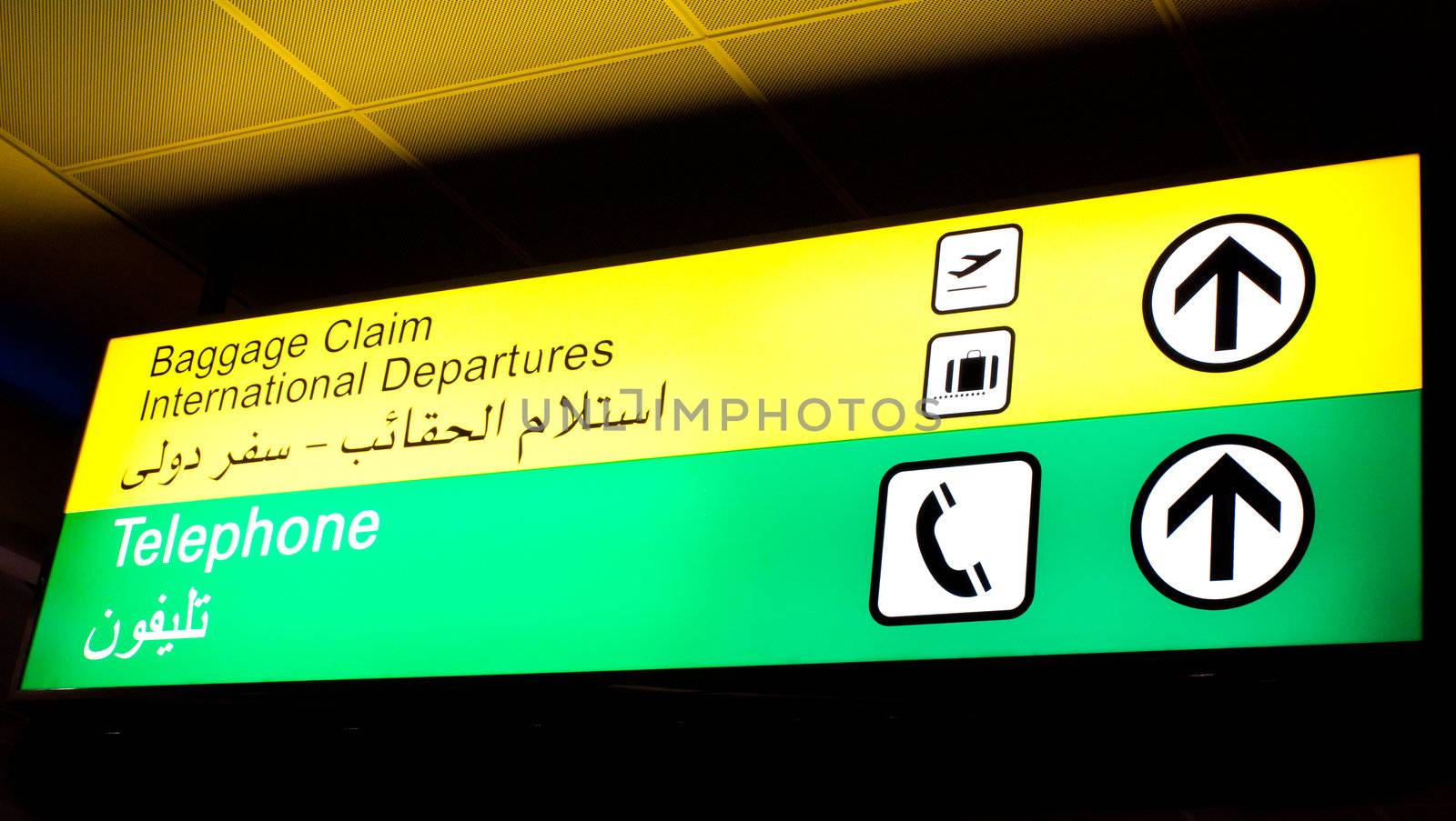 Baggage claim and telephone sign in an international airport in Middle East with Arabic information
