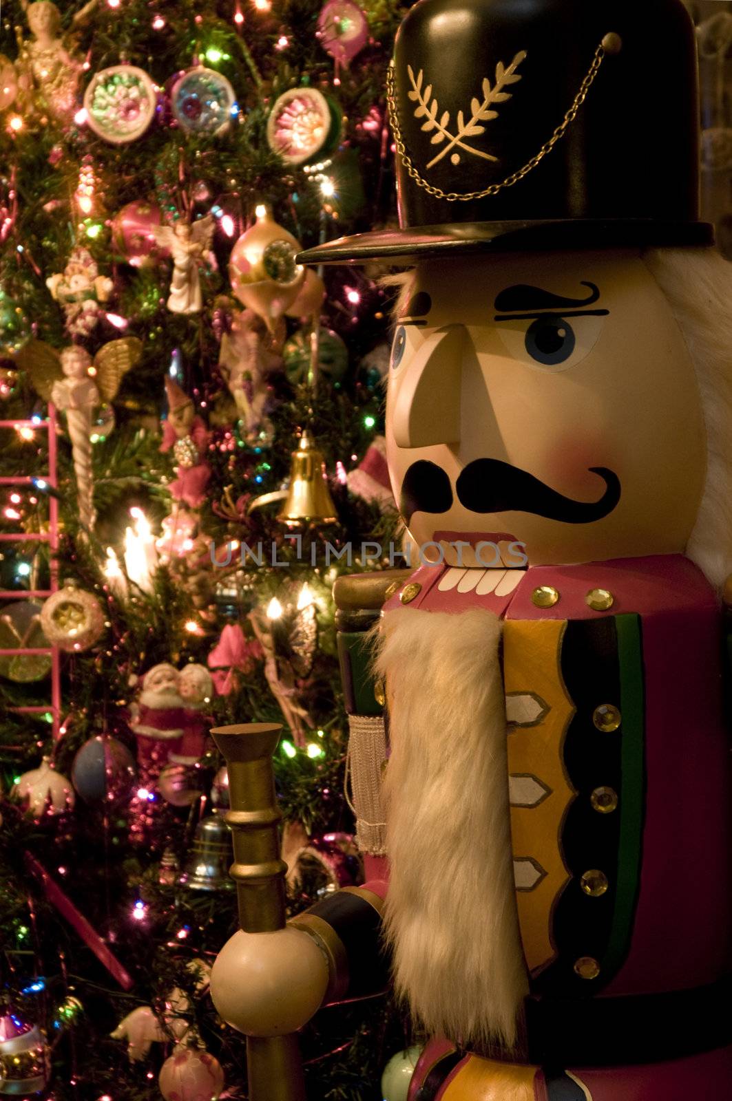 Selective focus on Nutcracker in front of Christmas tree.