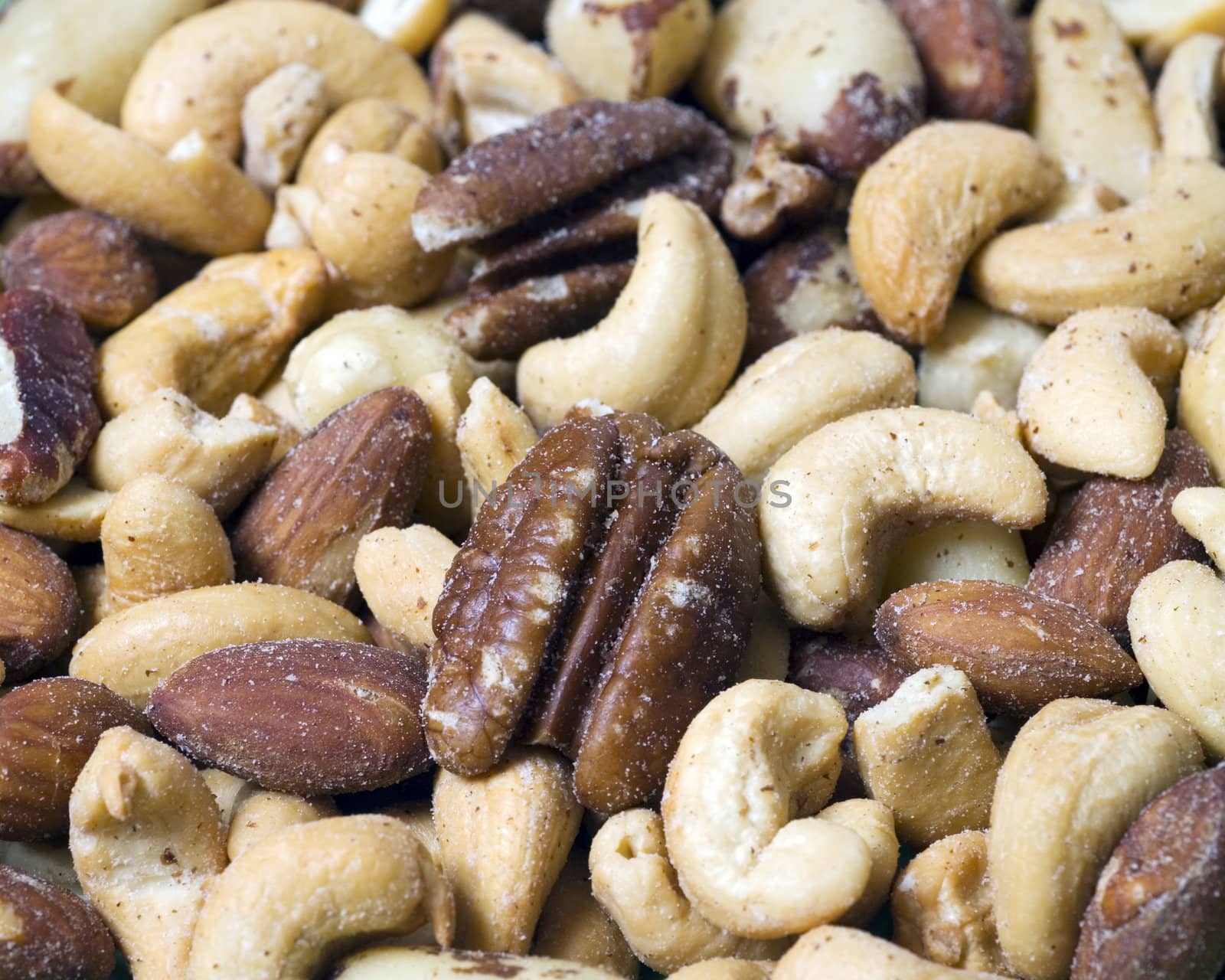 Macro shot with selective focus on a few of the foreground mixed nuts.