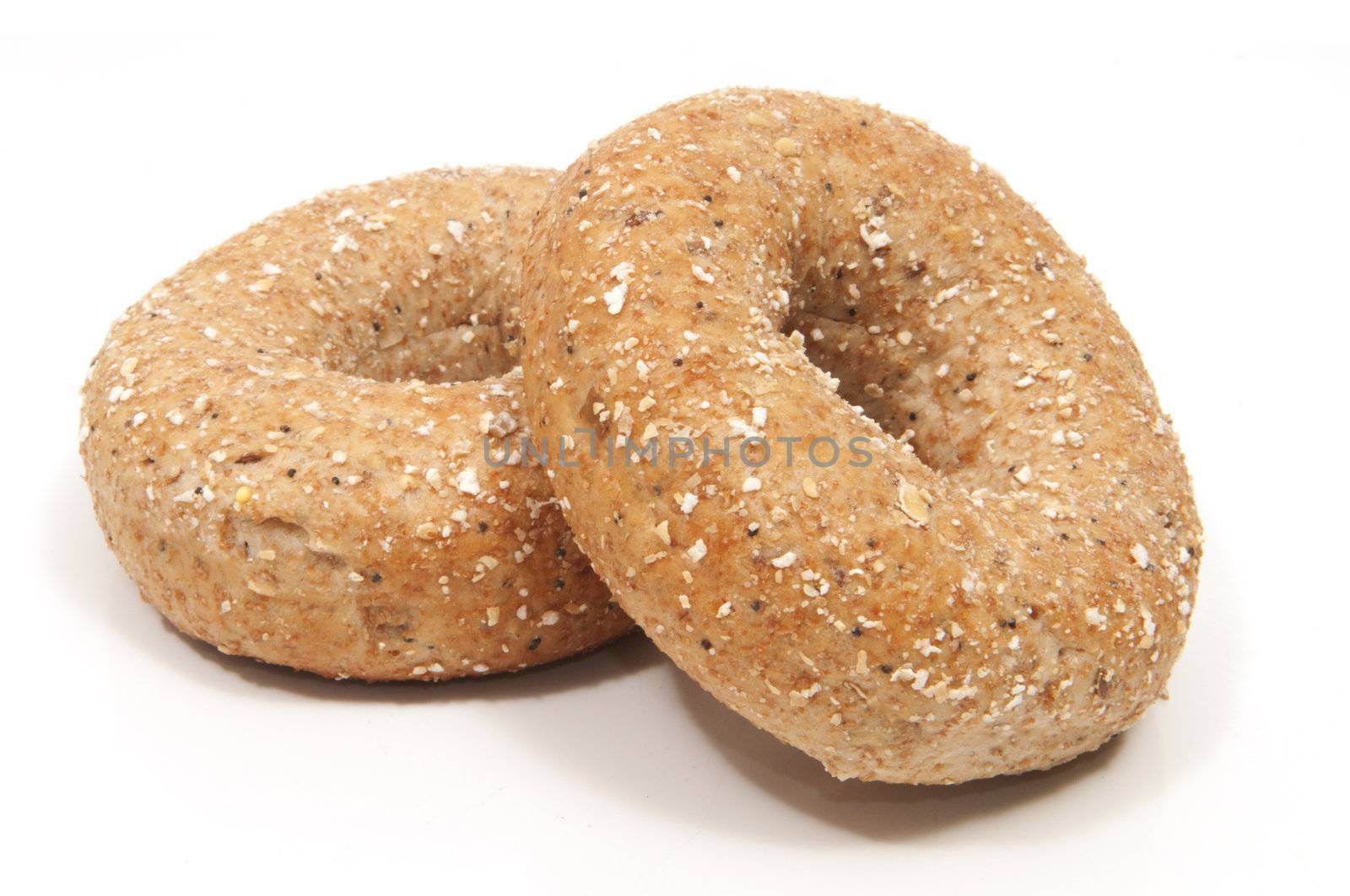 Two golden bagels isolated on white background