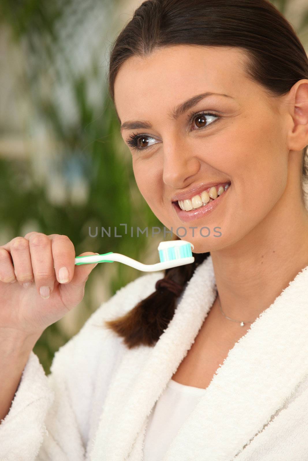 Woman brushing her teeth by phovoir