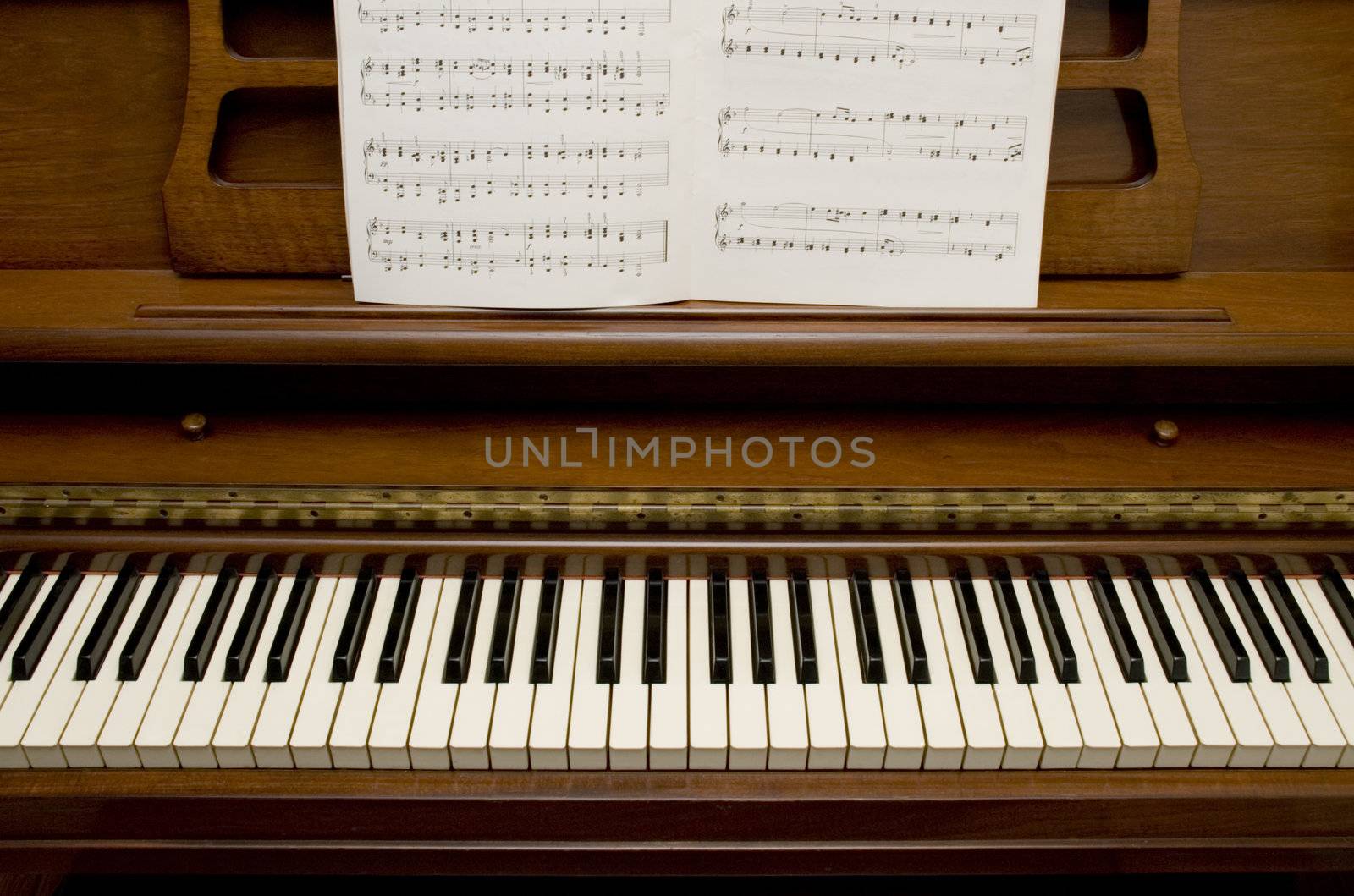 Looking down on 50's style piano with sheet music on the stand