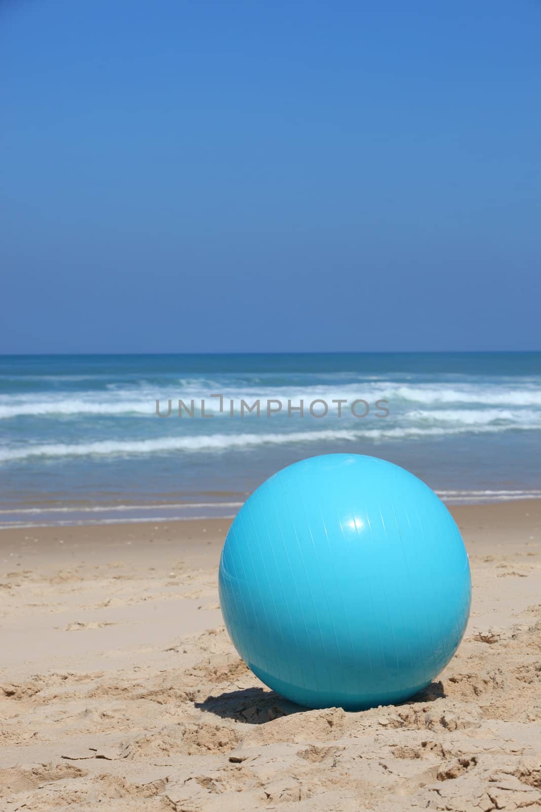 Ball left on a beach by phovoir