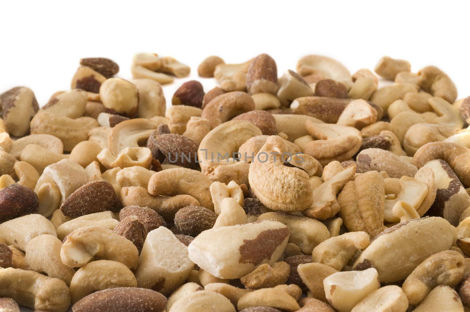 Selective focus on the mixed nuts with white copy space in the background