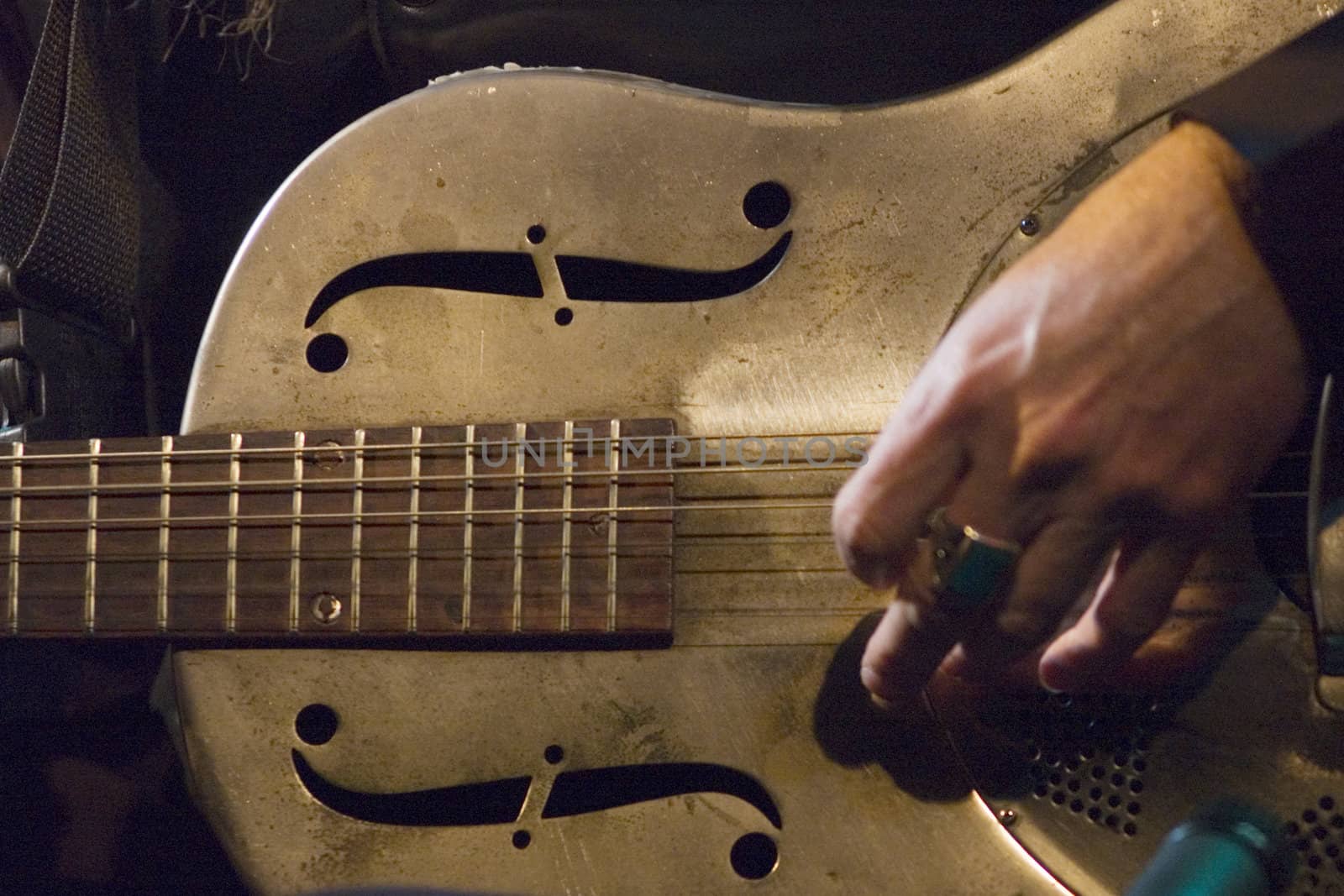 Macro photo with selective focus on the steel guitar, slow shutter with slight movement of hand.