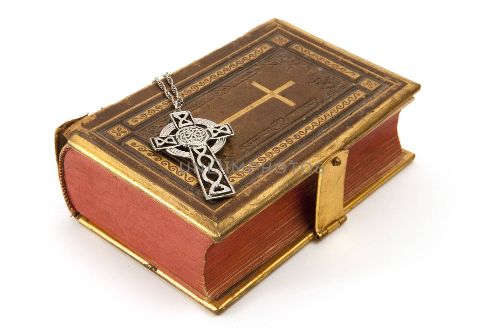 Cross on a antique Christian book with the cross symbol on the cover, isolated on white background