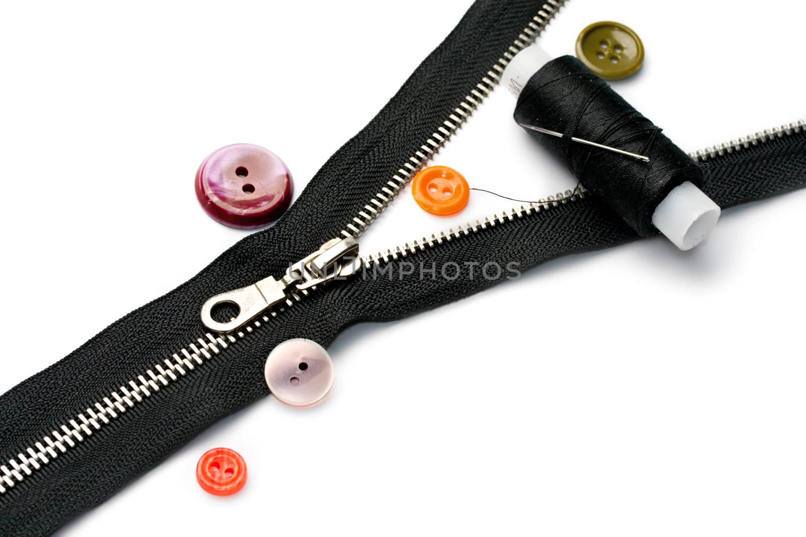 Zipper, thread and button isolated on white