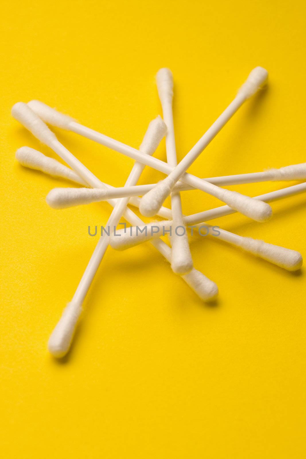 Cotton swabs isolated on yellow background